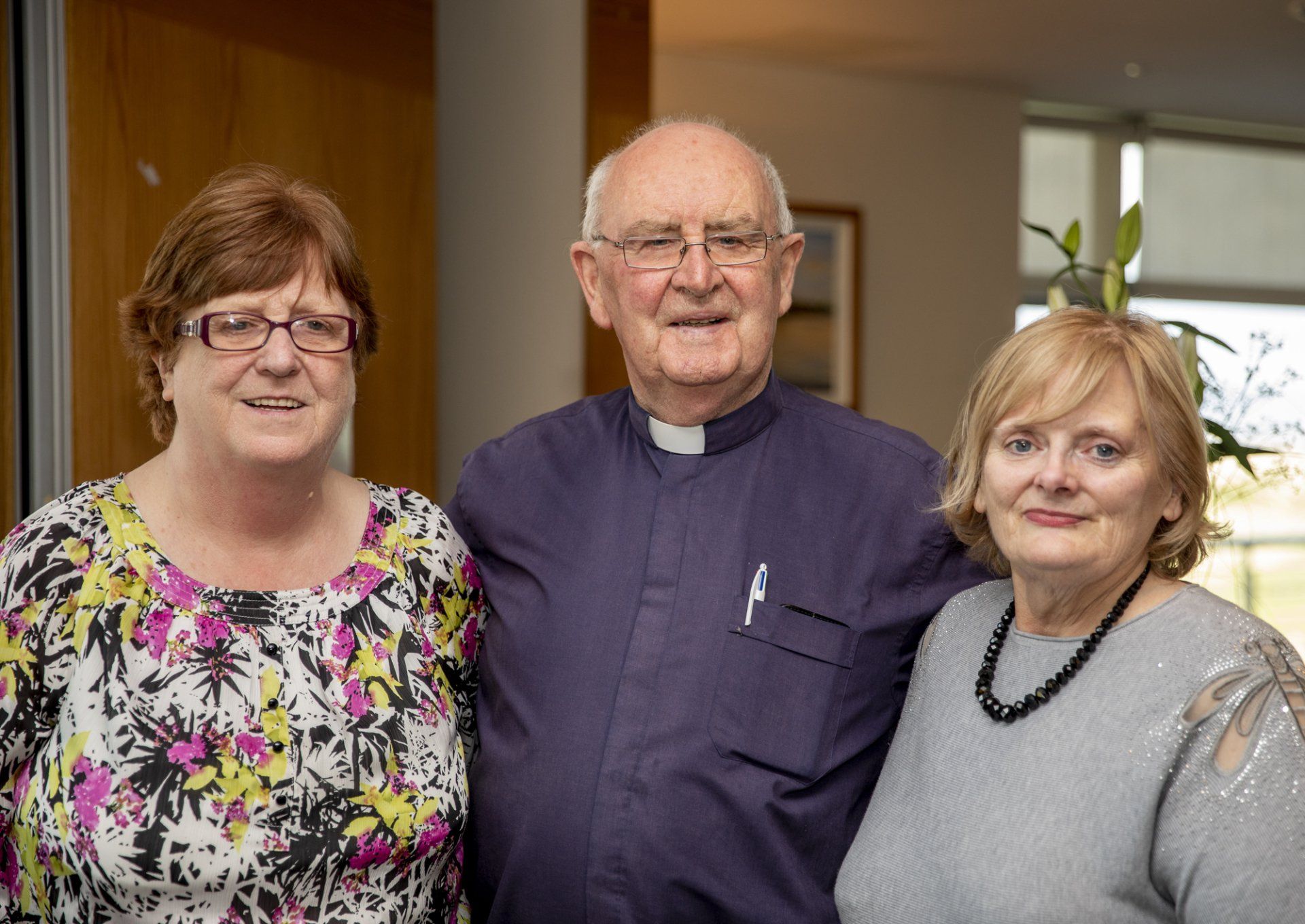 A man and two women are posing for a picture together.