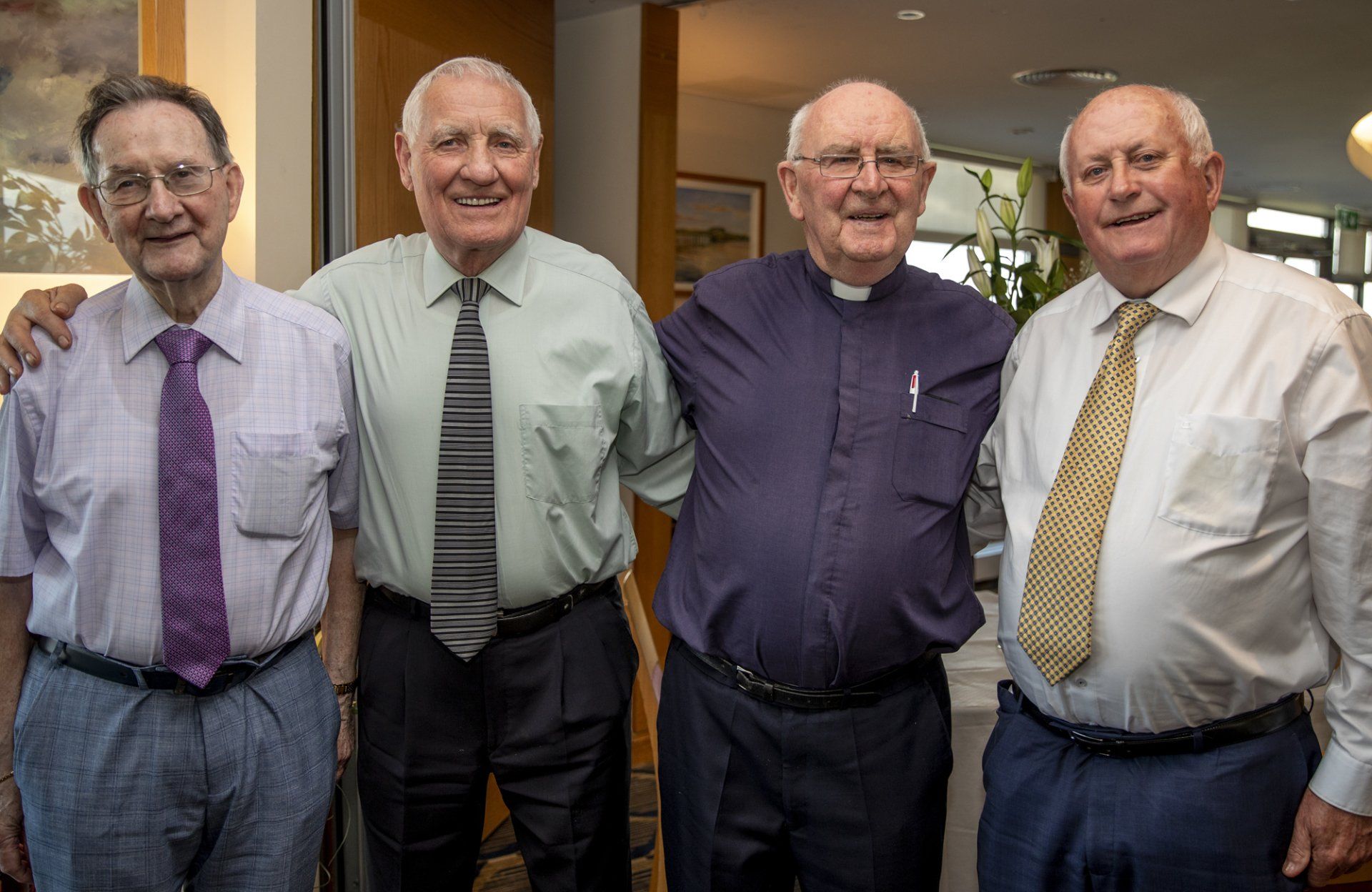 A group of four men are posing for a picture together.