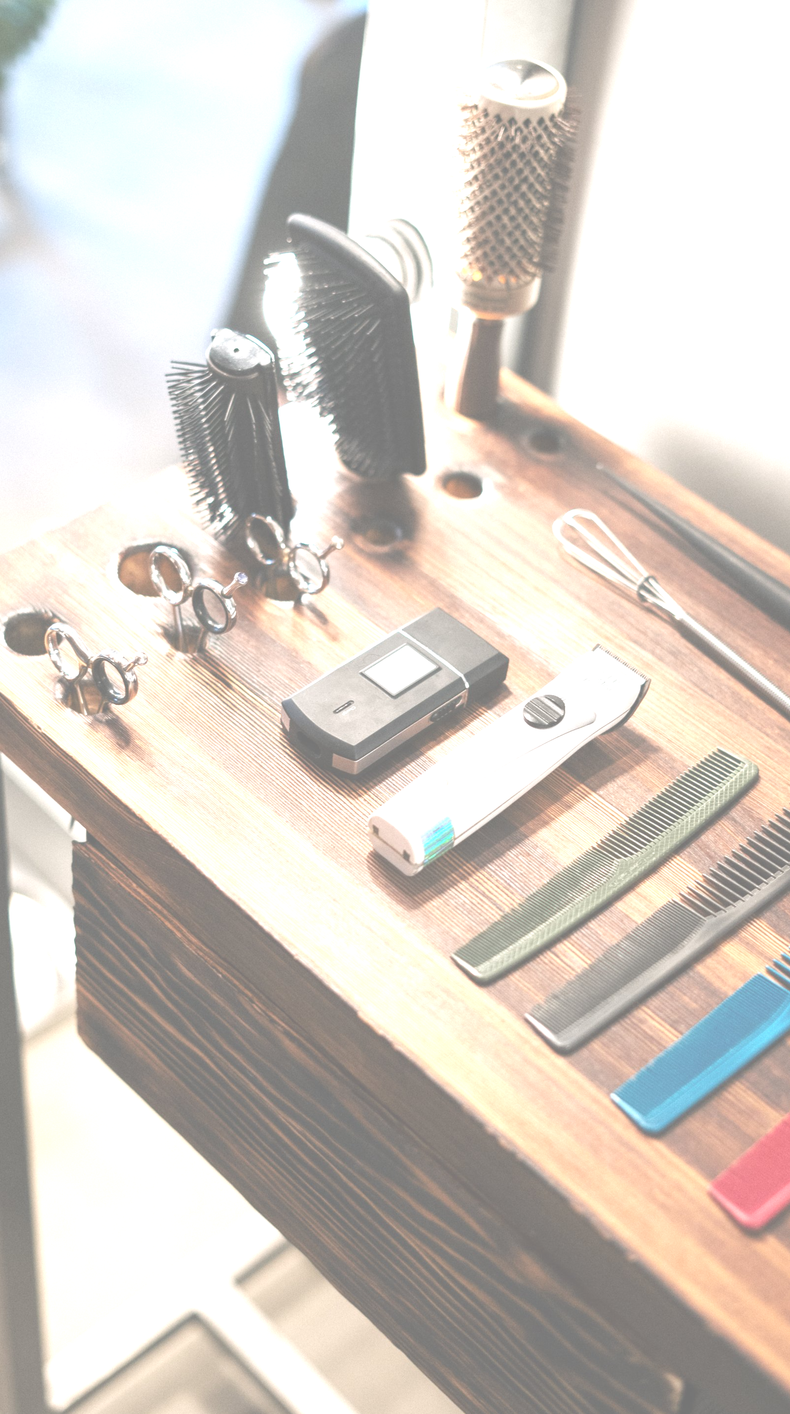 A wooden table with a bunch of hair brushes and combs on it
