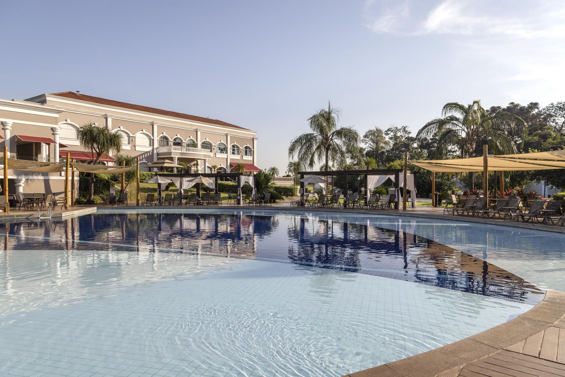 Uma grande piscina com um hotel ao fundo