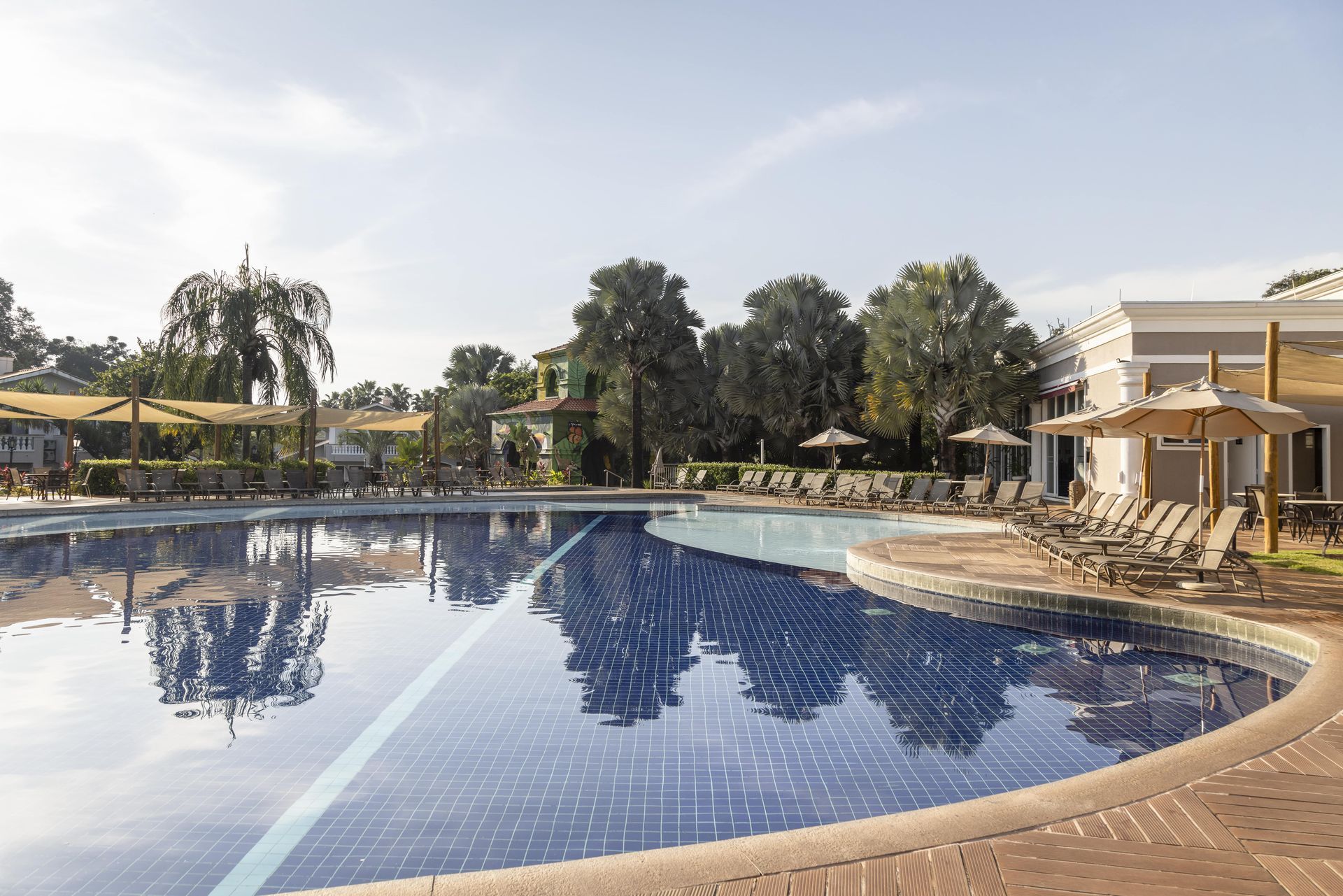 Uma grande piscina cercada por cadeiras e guarda-sóis em um resort.