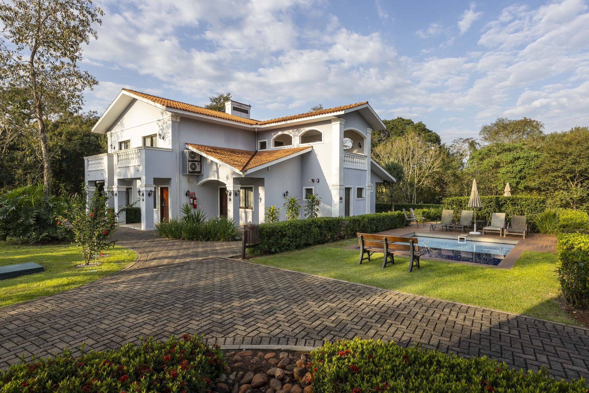 Uma grande casa branca com uma piscina no quintal.