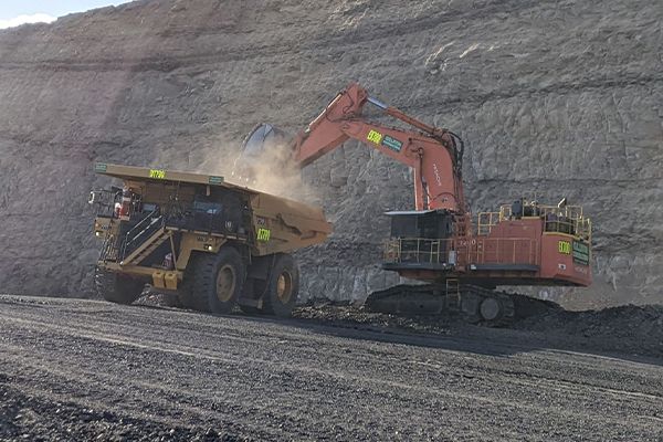 An excavator is loading a dump truck in a coal mine.