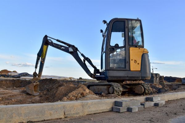 A small excavator is working on a construction site.