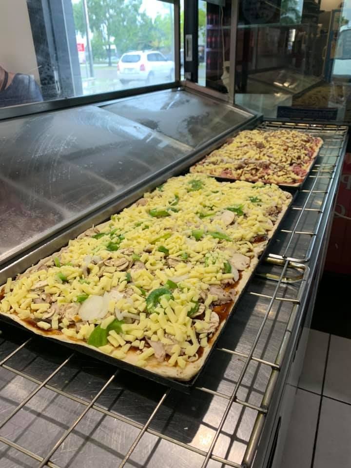 A Bunch Of Pizzas Are Sitting On A Counter In A Restaurant — Michelangelo's Pizza & Pasta in Kirwan, QLD