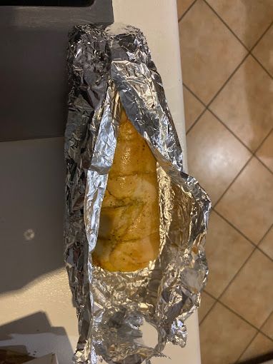A Piece Of Food Wrapped In Tin Foil Is Sitting On A Counter — Michelangelo's Pizza & Pasta in Kirwan, QLD