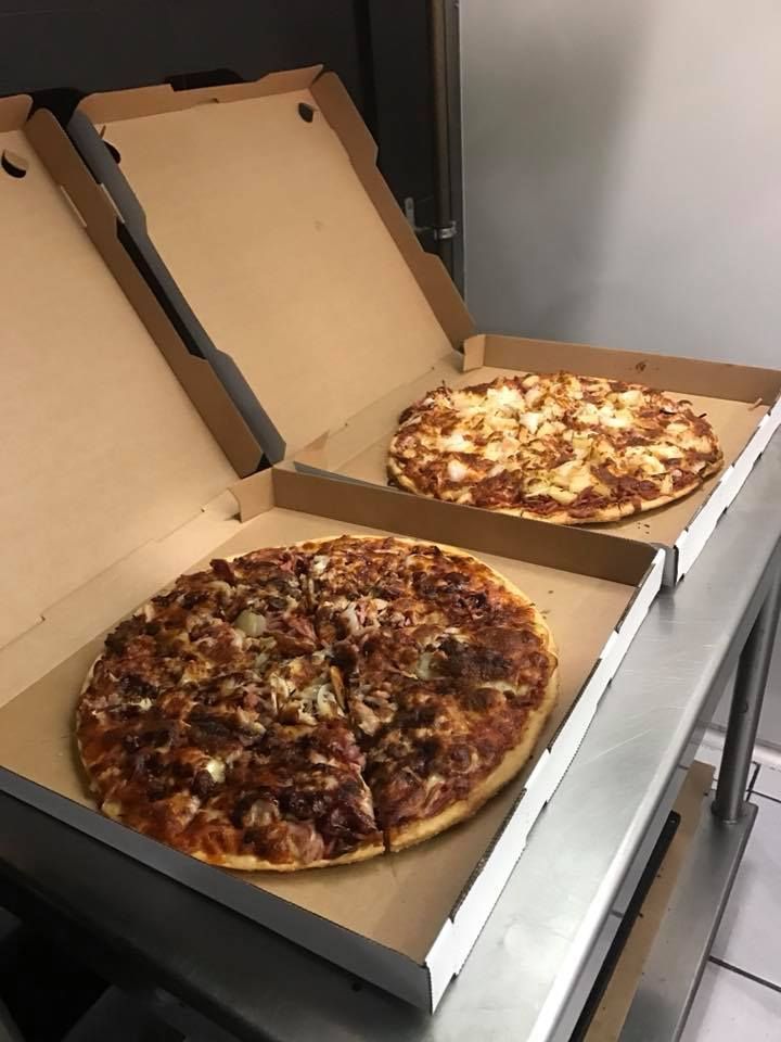 Two Pizzas Are Sitting In Cardboard Boxes On A Counter — Michelangelo's Pizza & Pasta in Kirwan, QLD