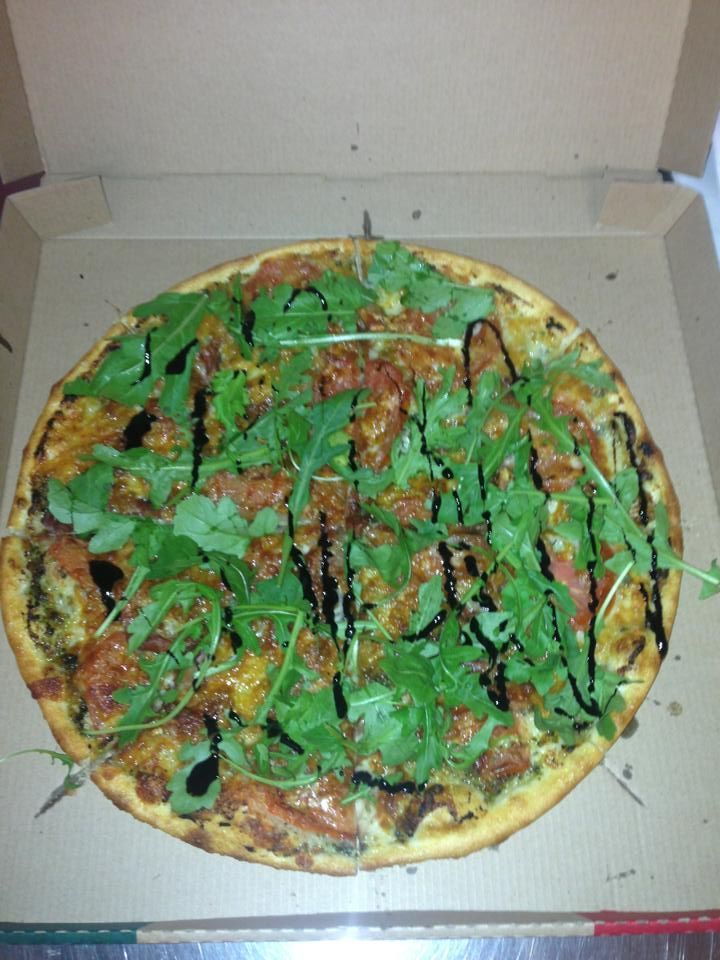 A Pizza in a Cardboard Box With Green Leaves on Top — Michelangelos Pizza & Pasta in  Aitkenvale, NSW