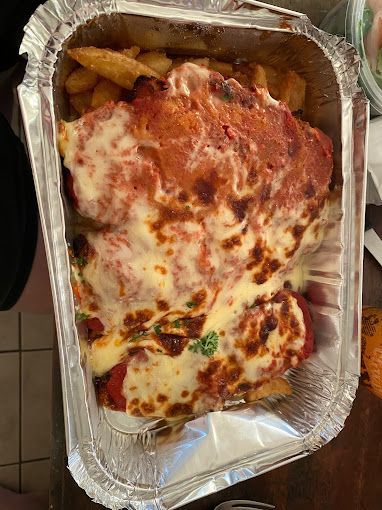 Aluminum Foil Container Filled With Chicken Parmesan And French Fries — Michelangelo's Pizza & Pasta in Kirwan, QLD