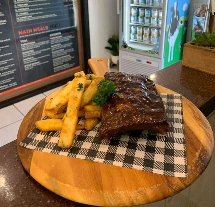 Ribs And French Fries On A Wooden Cutting Board — Michelangelo's Pizza & Pasta in Kirwan, QLD