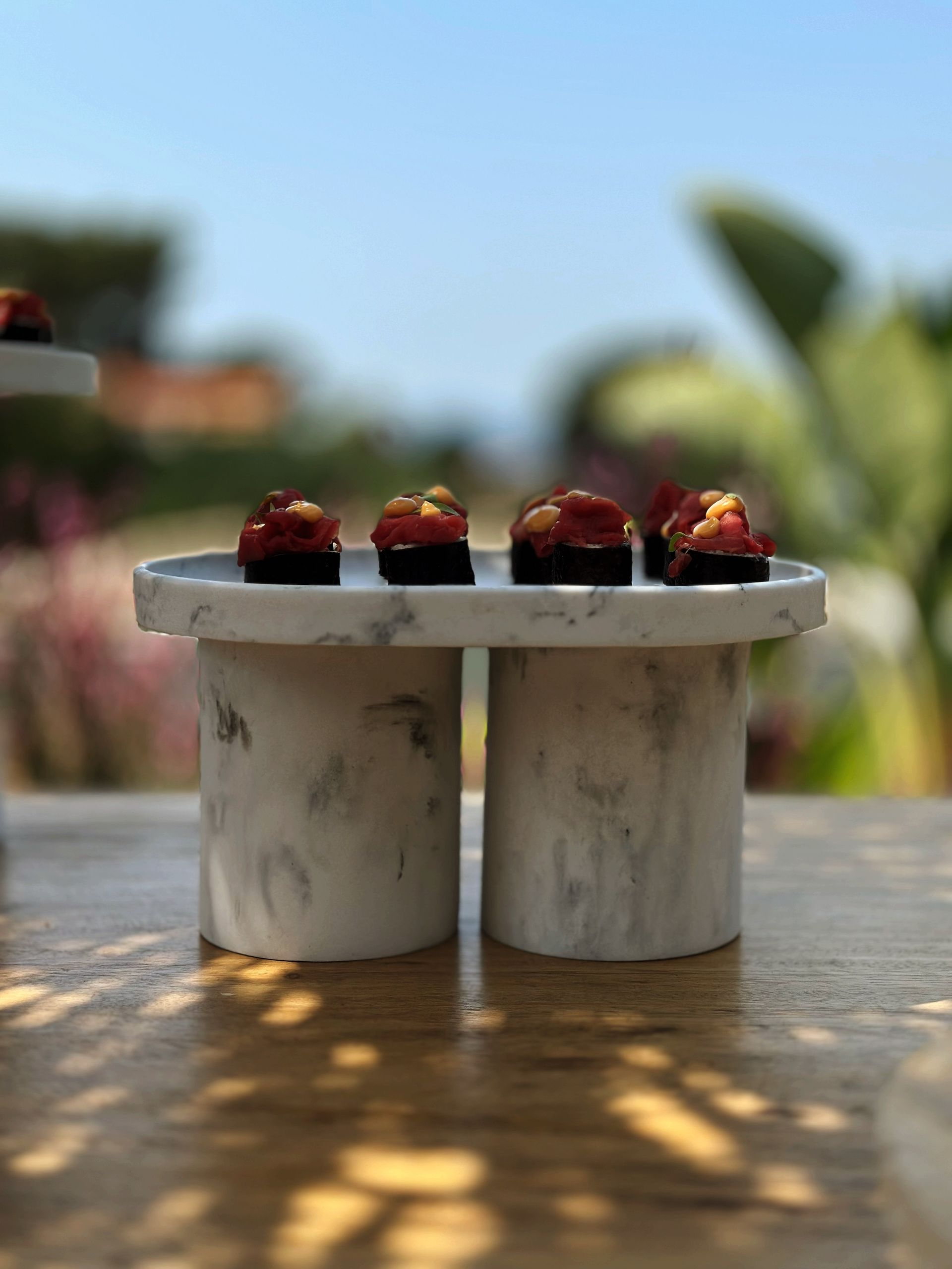 A couple of marble plates with food on them on a table.