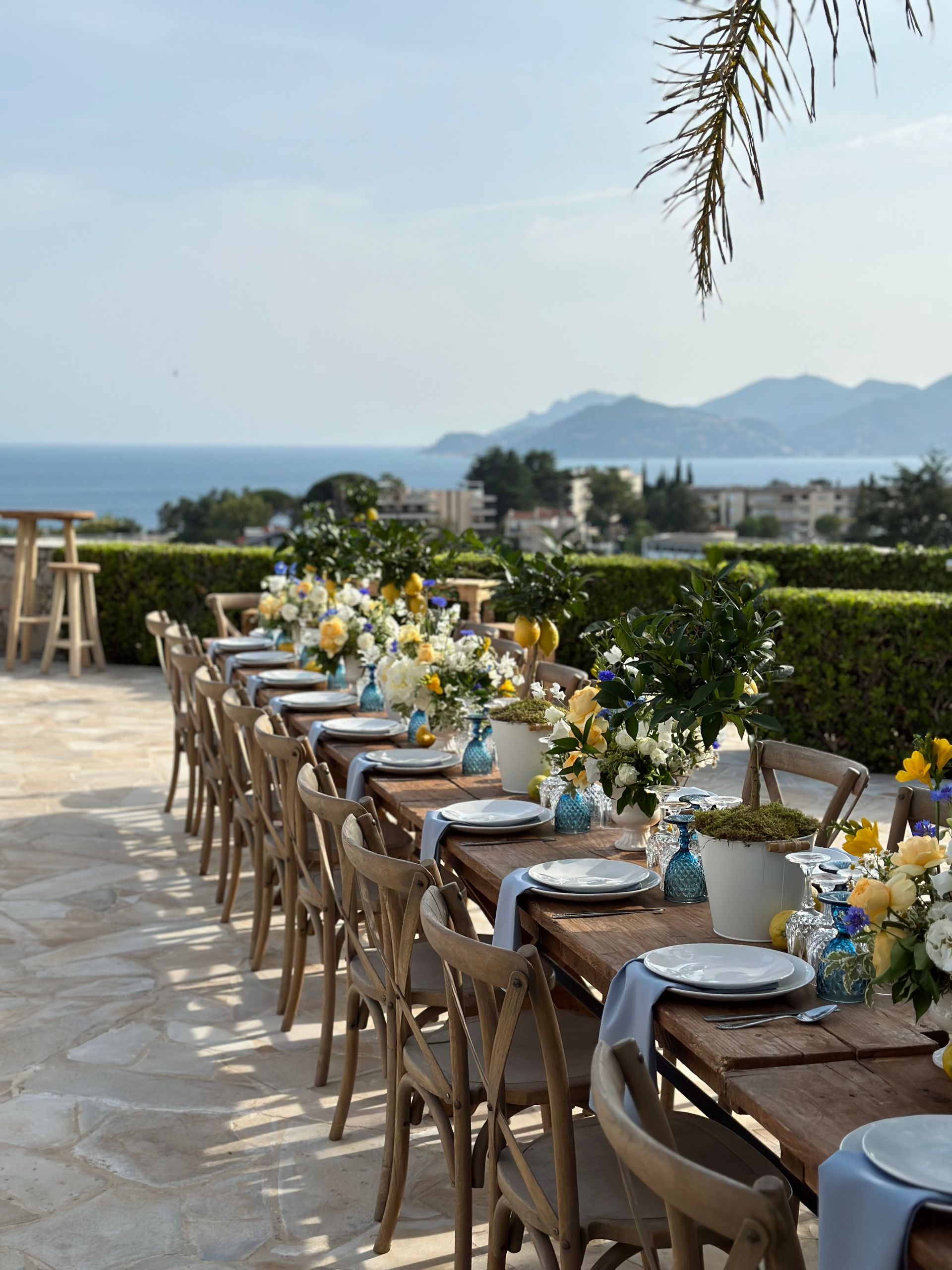 A long table with plates and vases of flowers on it