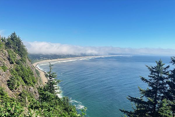 a view of the ocean from a cliff on a sunny day .