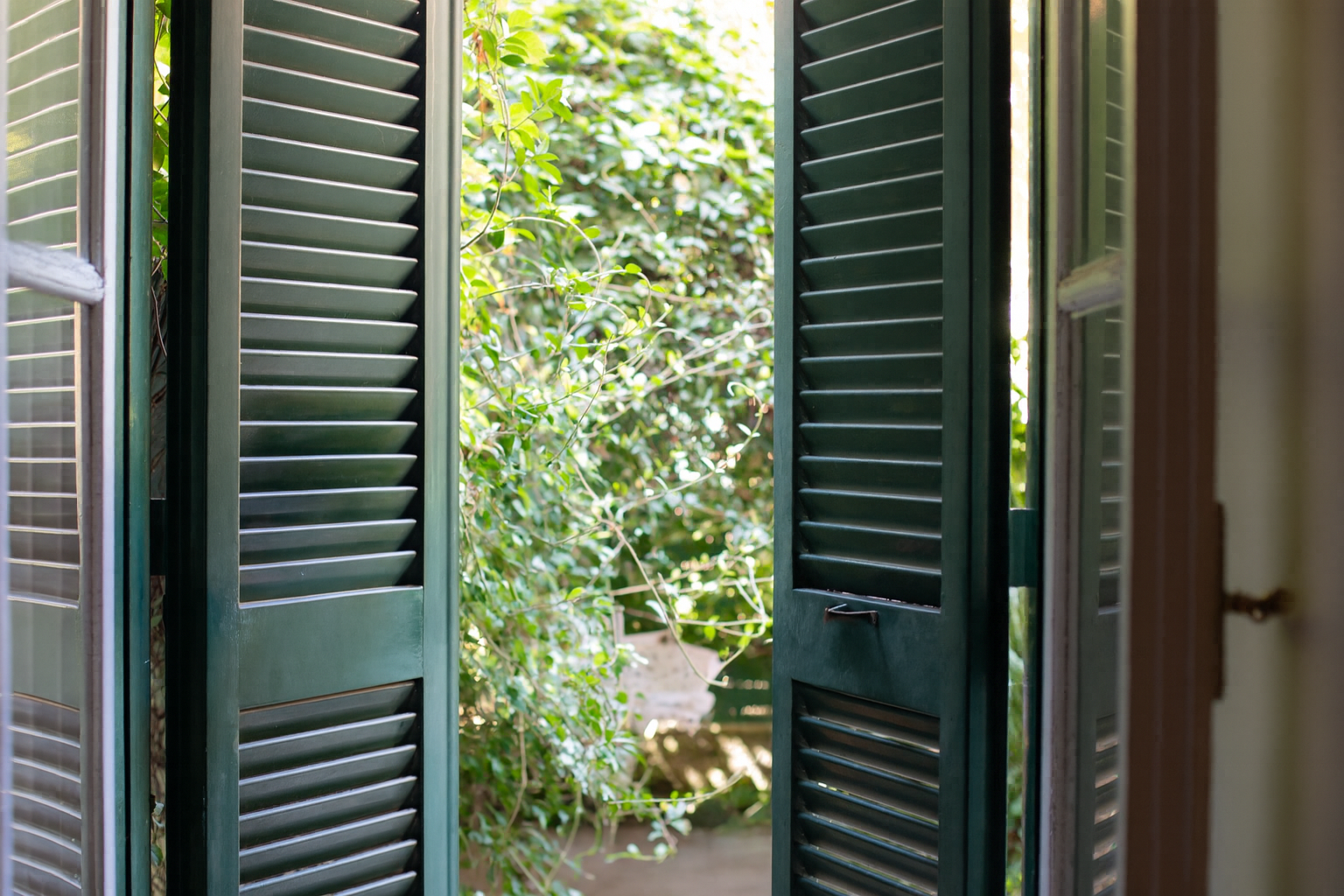 Cancello in metallo nero con disegno geometrico, montato su un edificio.