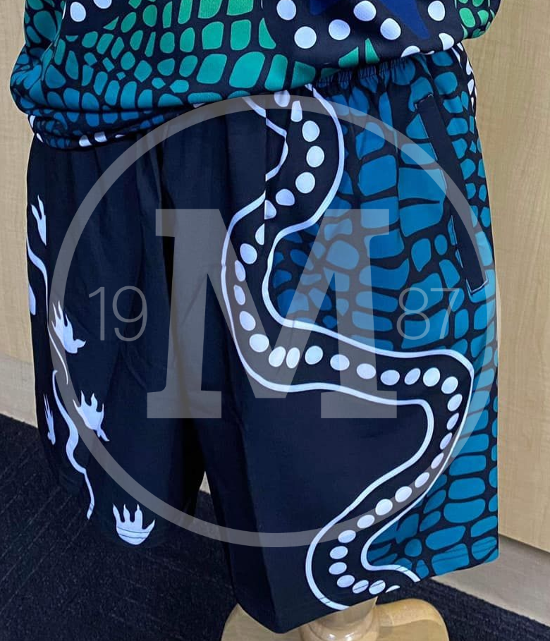 Shorts with a black background featuring white dotted serpentine patterns and a blue, teal-toned crocodile skin print.