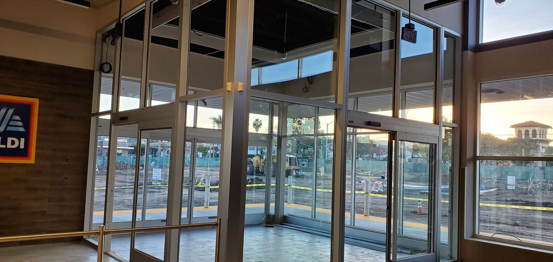 Entrance of an Aldi grocery store with revolving doors and large windows.