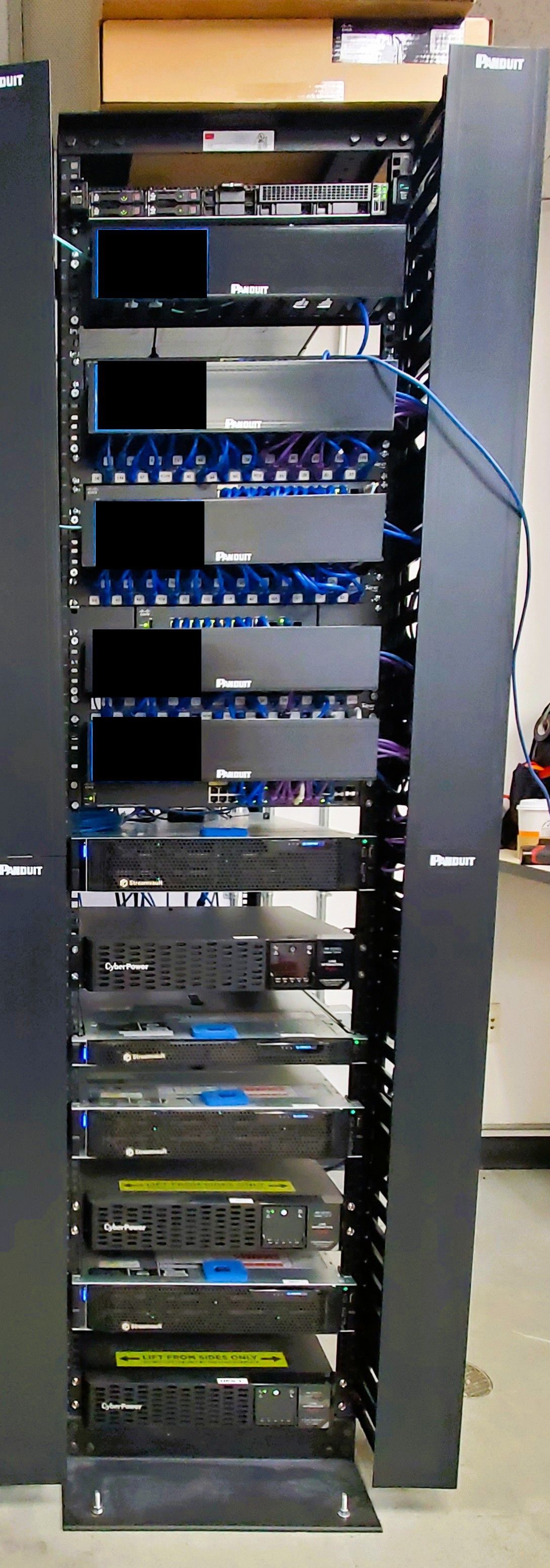 A server rack with multiple black computer servers and related equipment in a vertical cabinet.