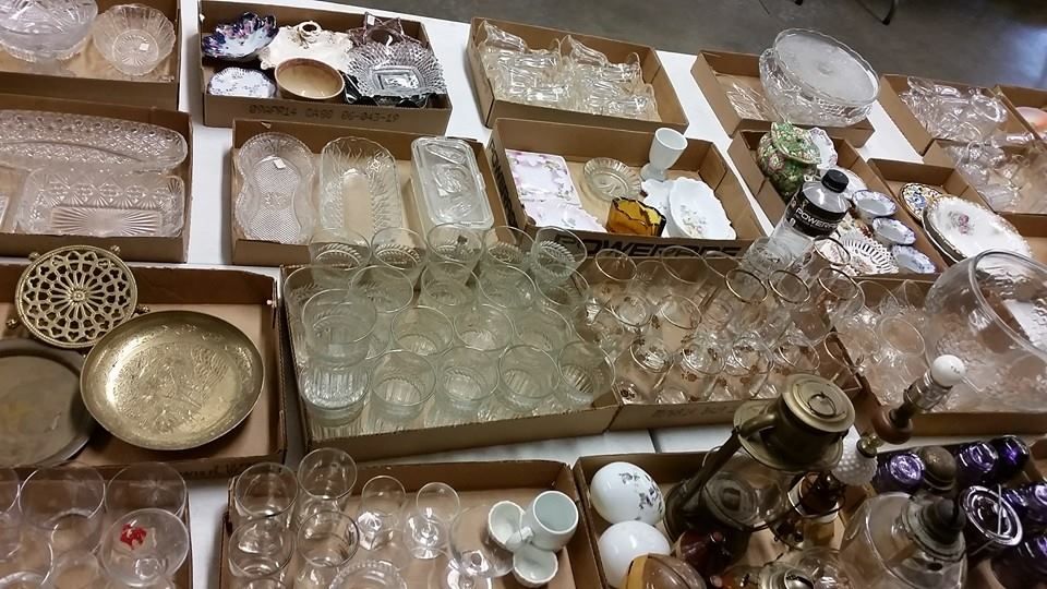 Assorted glassware, bowls, and decorative dishes neatly arranged on shelves in a shop display