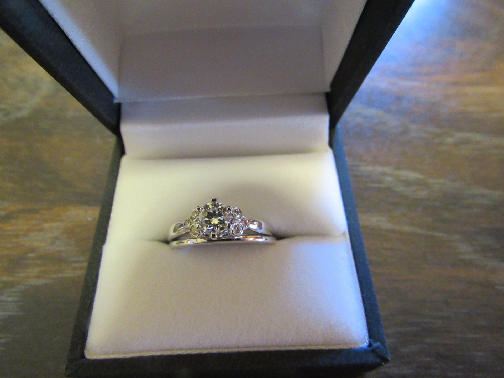 Diamond ring in an open black jewelry box on a wooden table