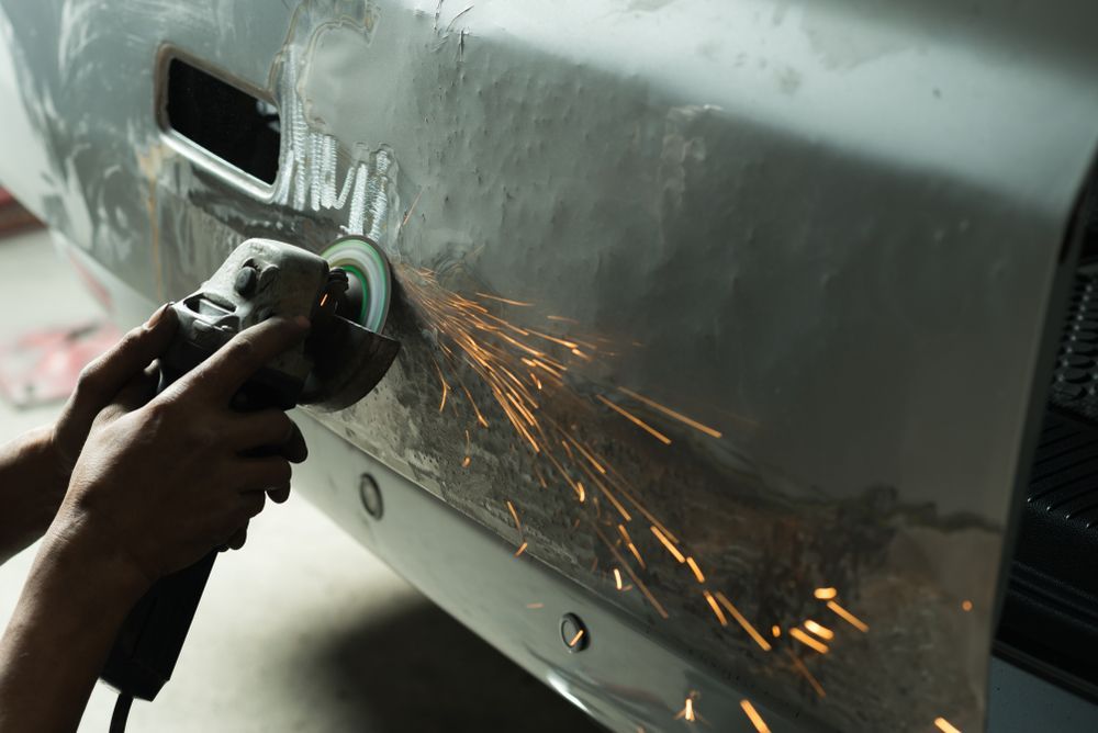 Person Using an Angle Grinder, Creating Sparks, on a Vehicle's Body Panel — Bob Kolln Automotive In Gorokan, NSW