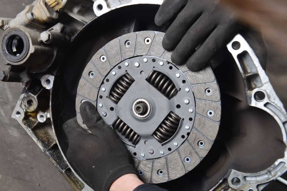 Hands in Black Gloves Installing a Clutch Disc Into a Car Transmission — Bob Kolln Automotive In Warnervale, NSW
