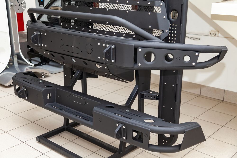Black Off-road Bumpers and Accessories Displayed on Metal Stands in a Workshop — Bob Kolln Automotive In Charmhaven, NSW
