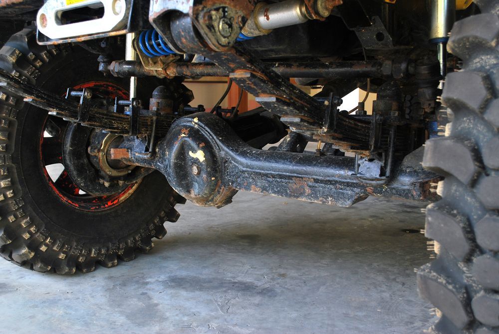 Off-road Vehicle's Black Axle and Suspension With a Red Rim — Bob Kolln Automotive In Wadalba, NSW