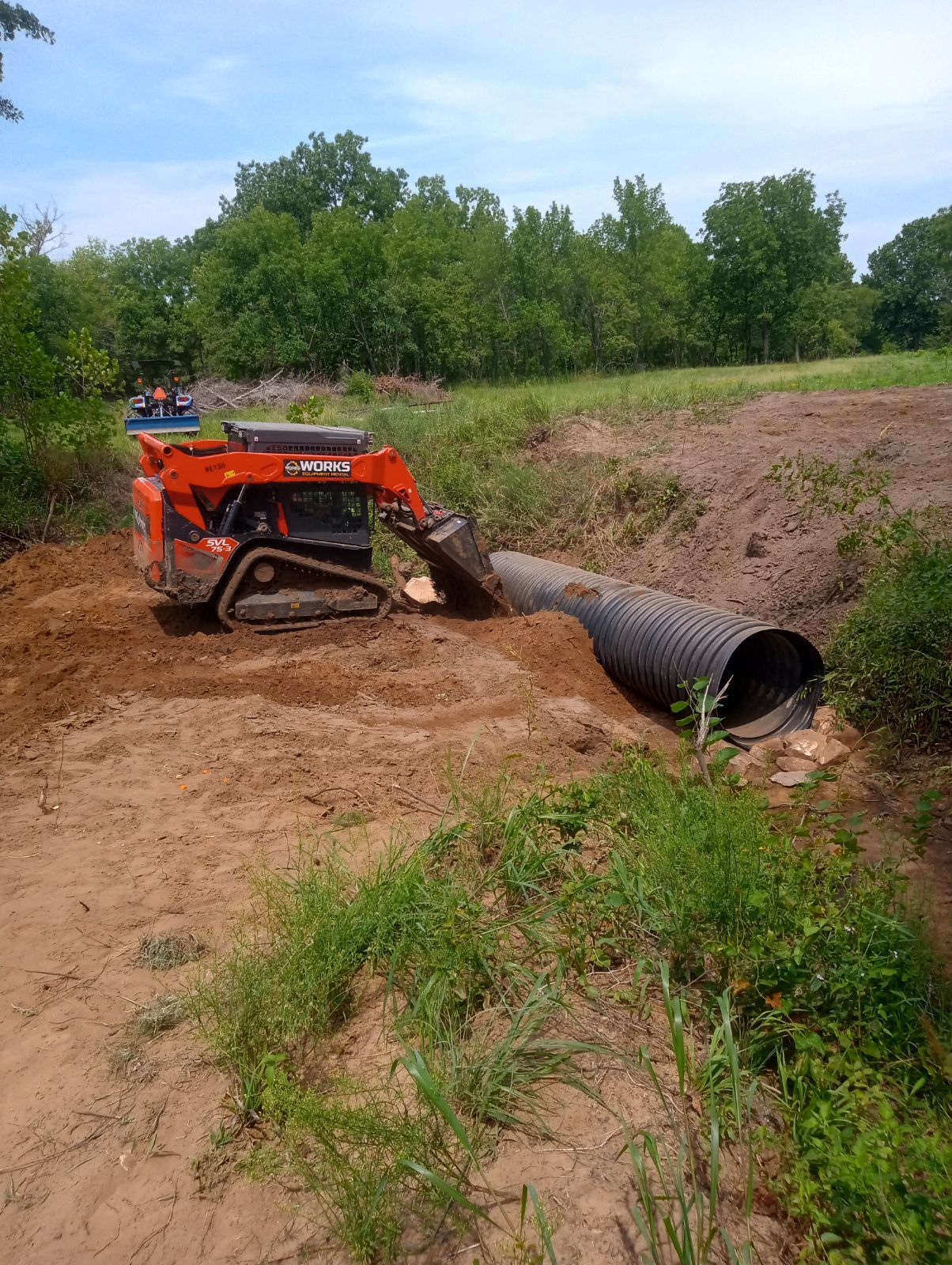 An aerial view of a bulldozer working on a dirt road.