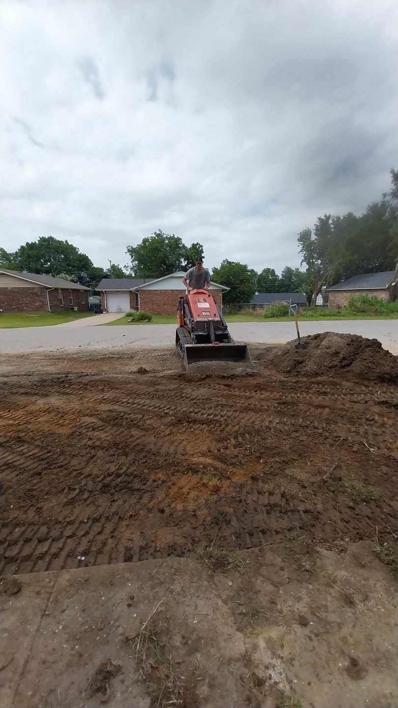 A rake is sitting on top of a pile of mulch.