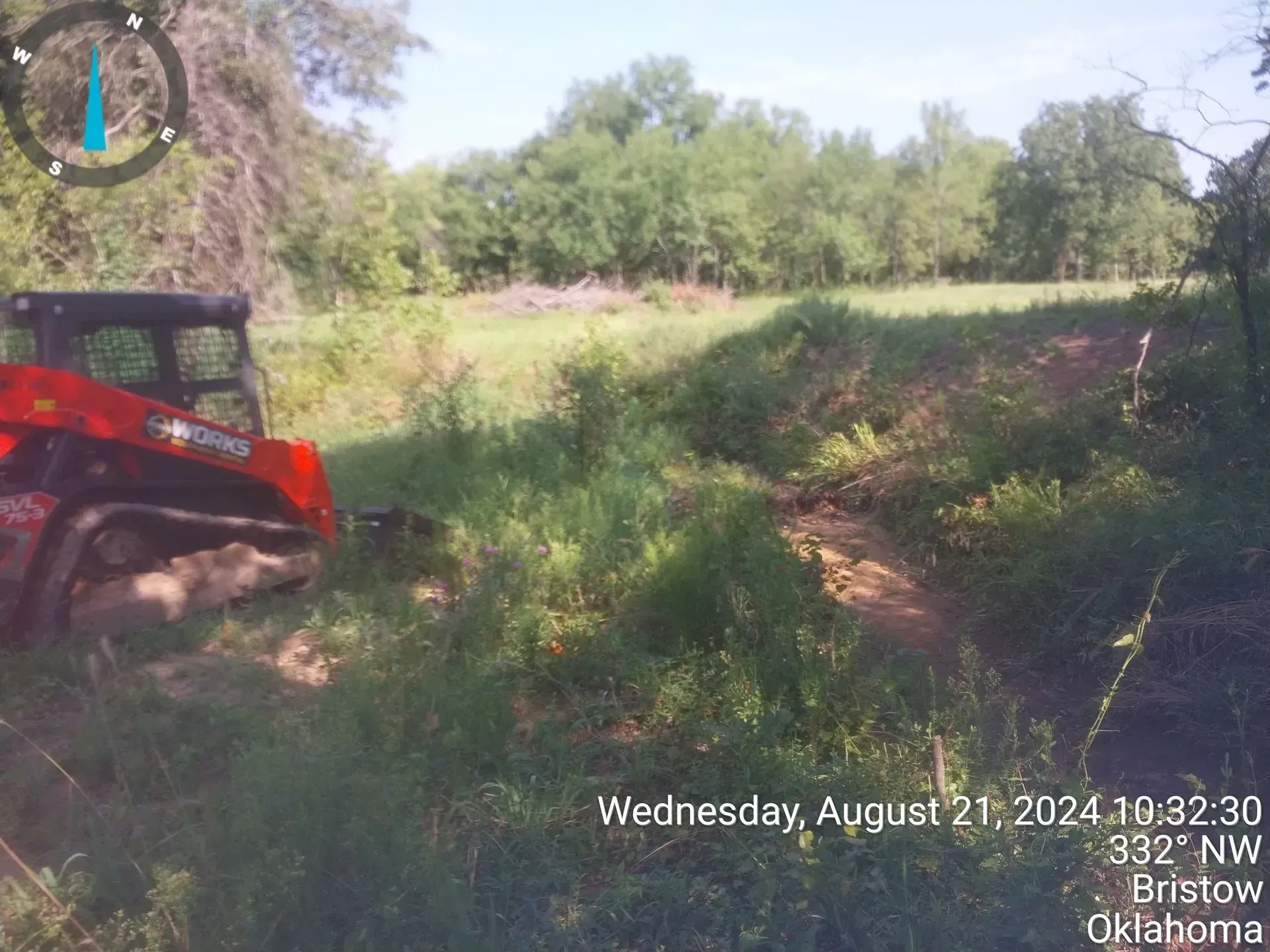 A red tractor is parked in the middle of a grassy field.