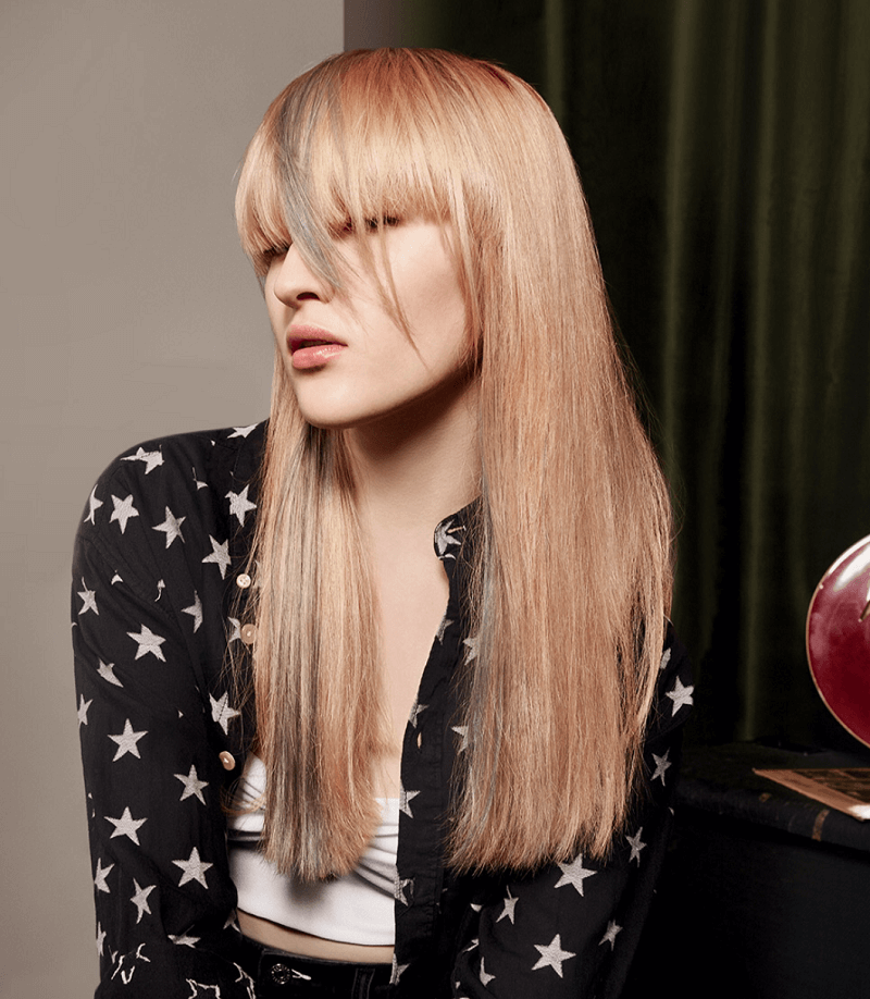 ragazza con frangetta e capelli lisci biondi