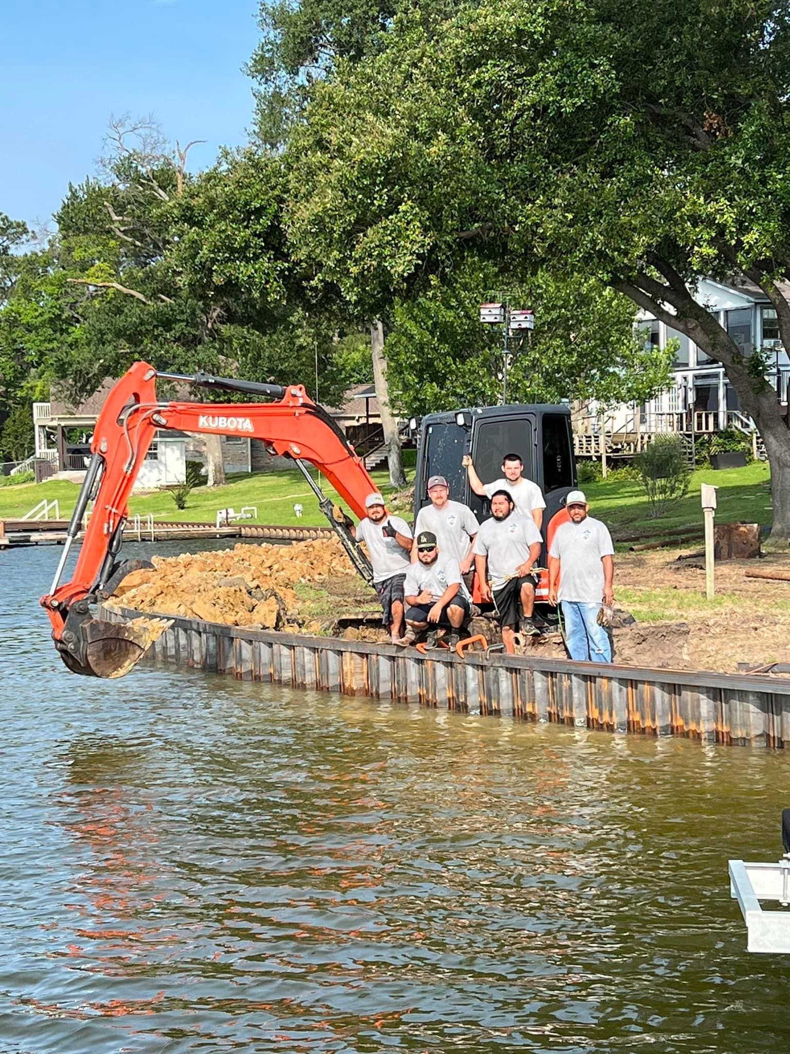 A group of men are standing next to a large excavator in the water.