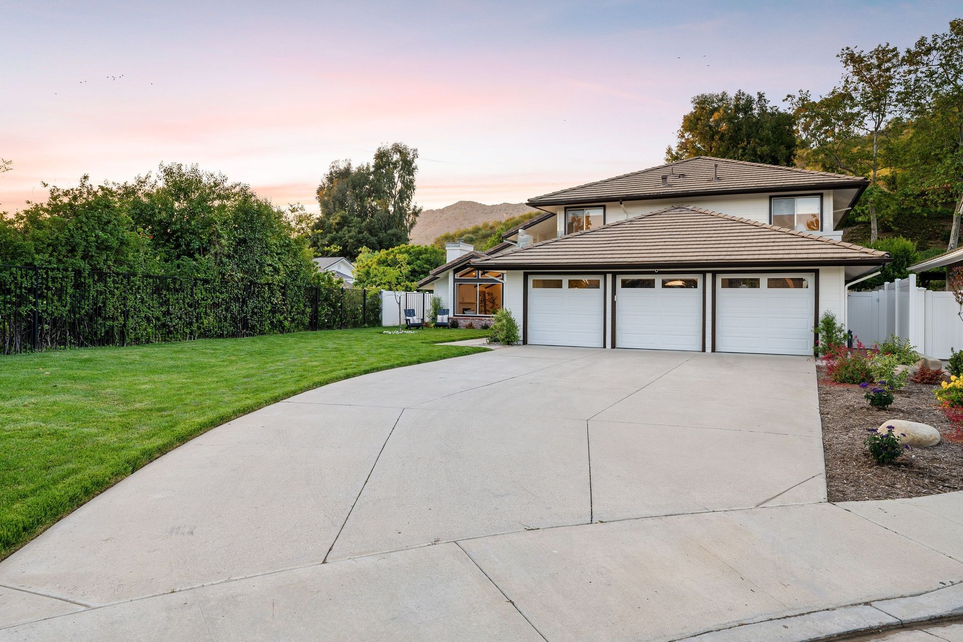 A house with three garage doors and a concrete driveway