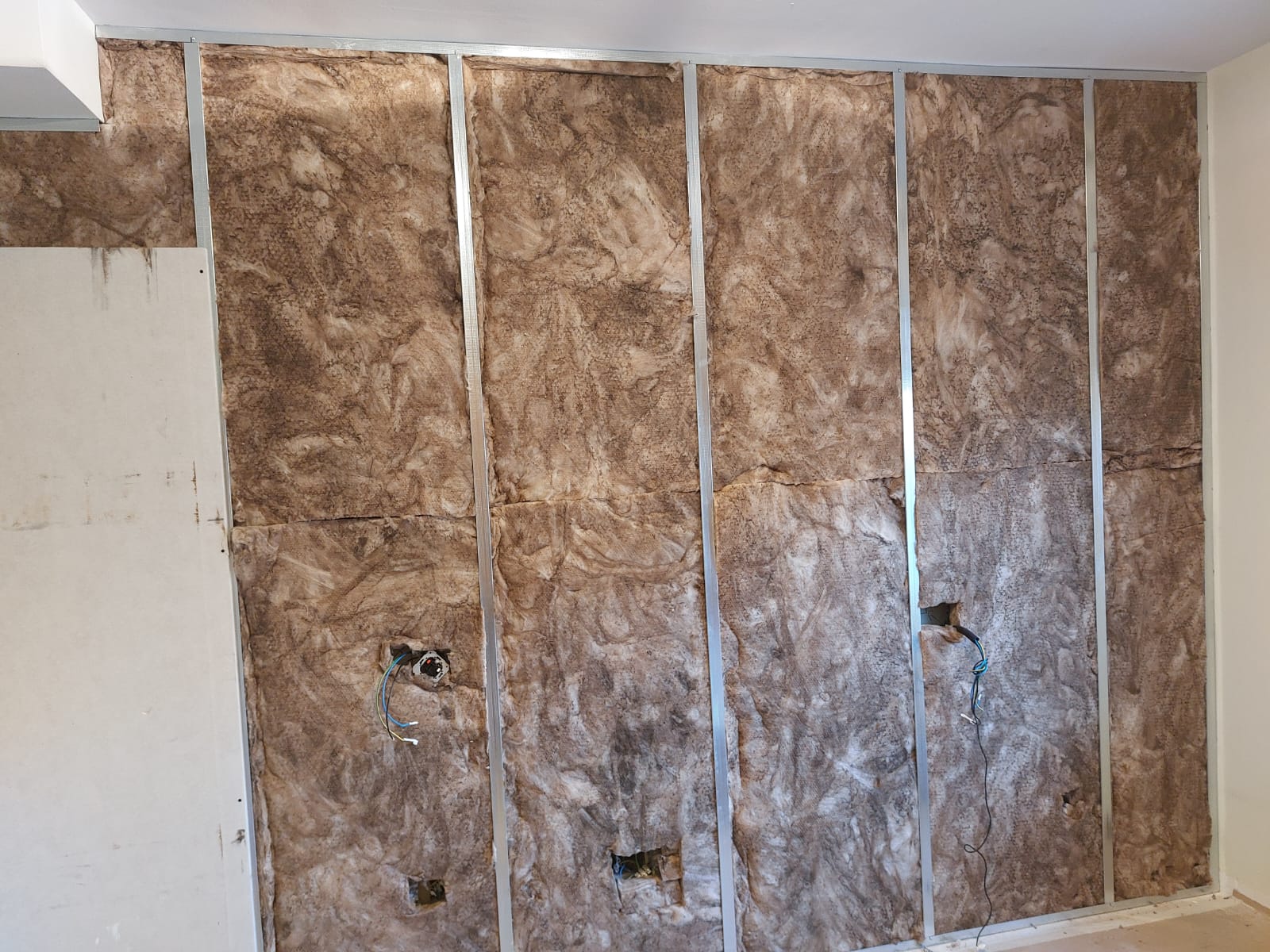 Una habitación con una pared cubierta de aislamiento y cables eléctricos.