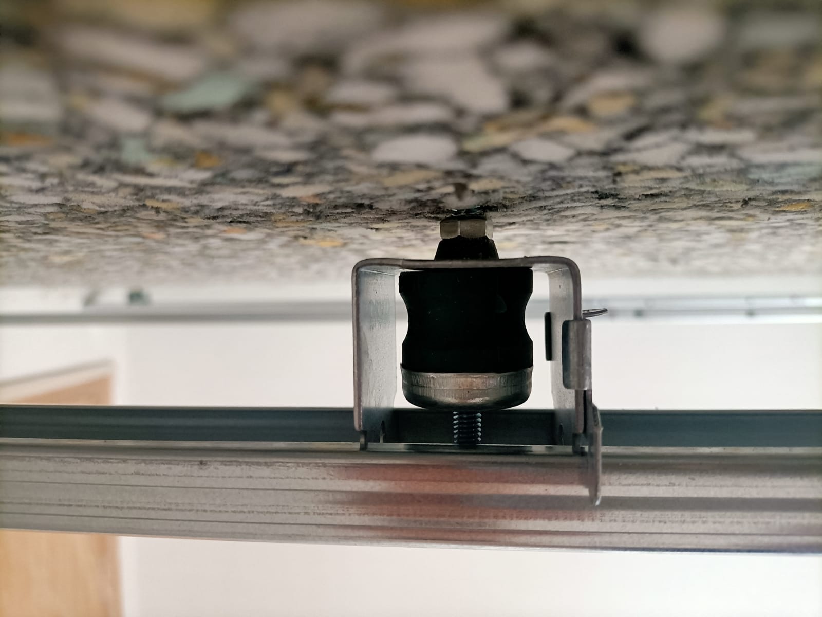 Un primer plano de un soporte metálico fijado al techo.