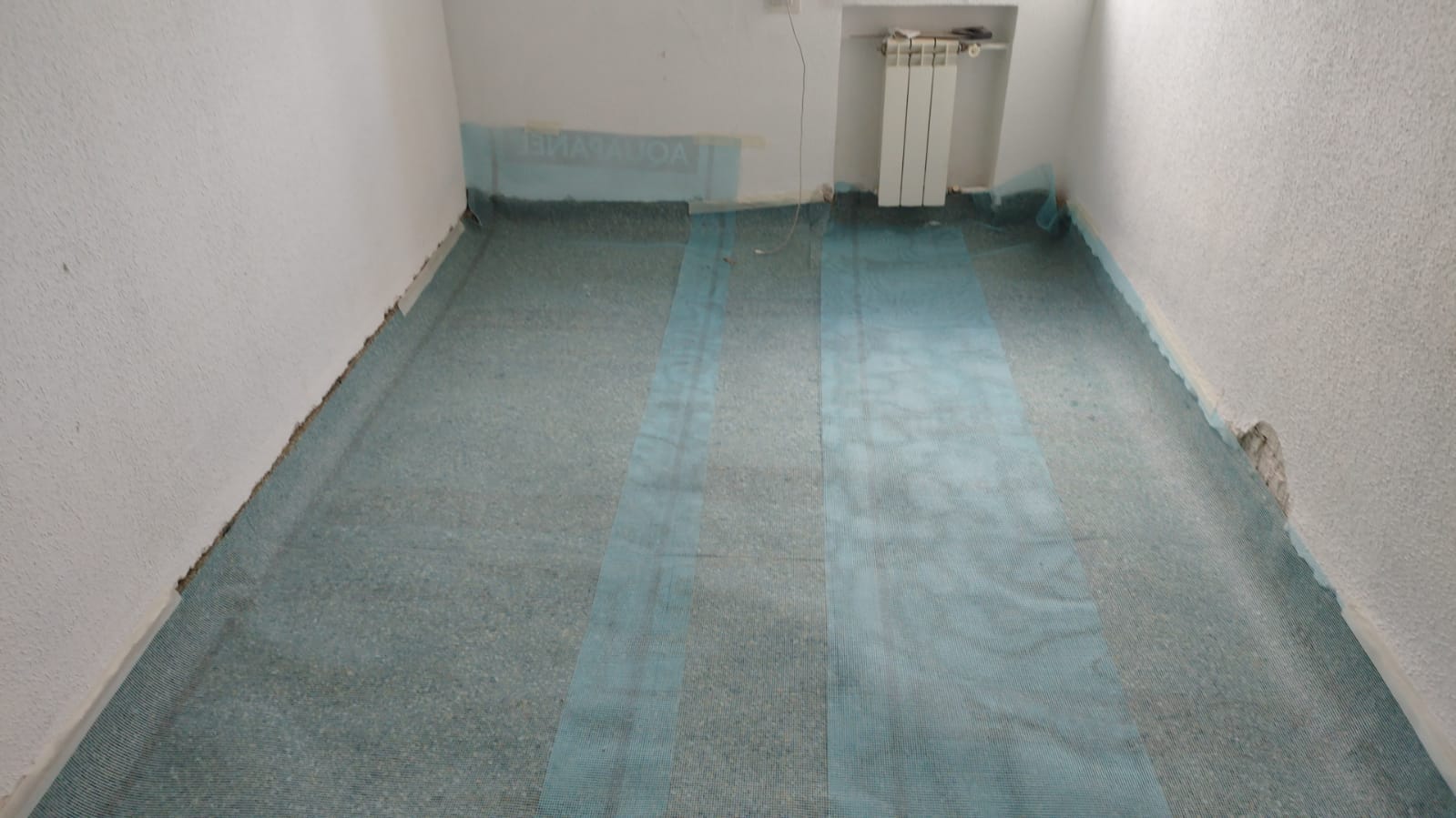 Una habitación con suelo azul y paredes blancas.