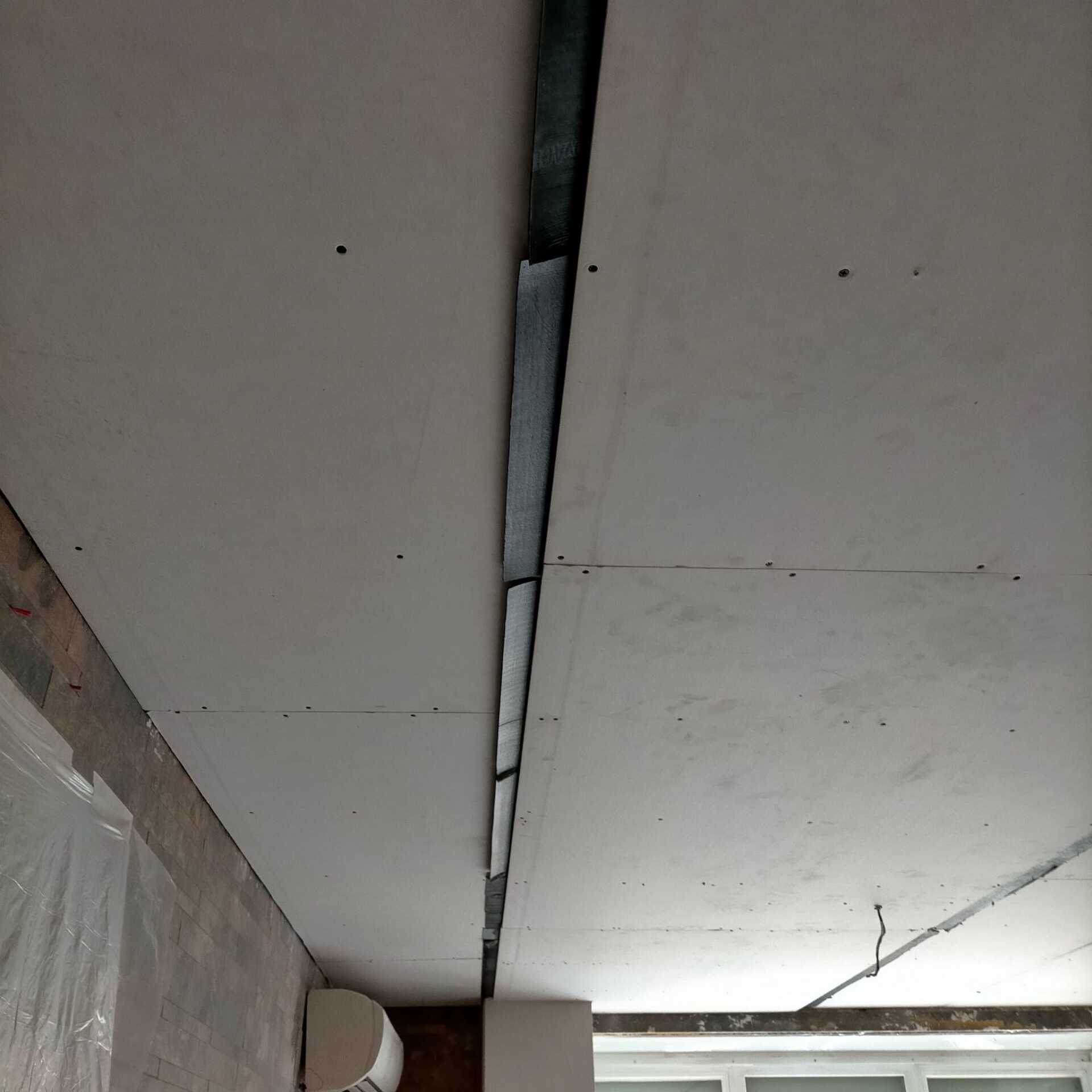 Se está remodelando un techo blanco con un agujero.