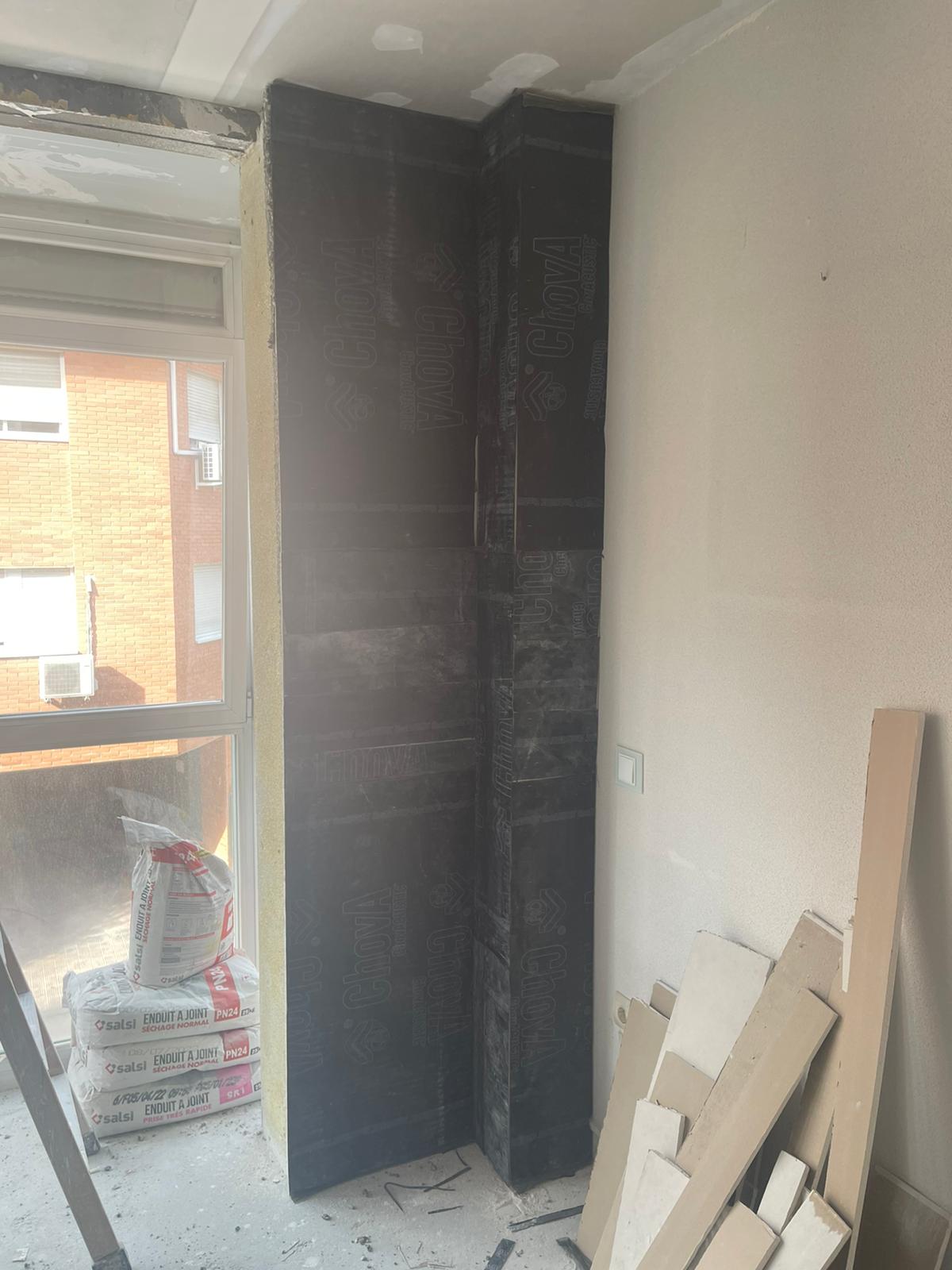 Una habitación en construcción con una pared de ladrillos y una ventana.