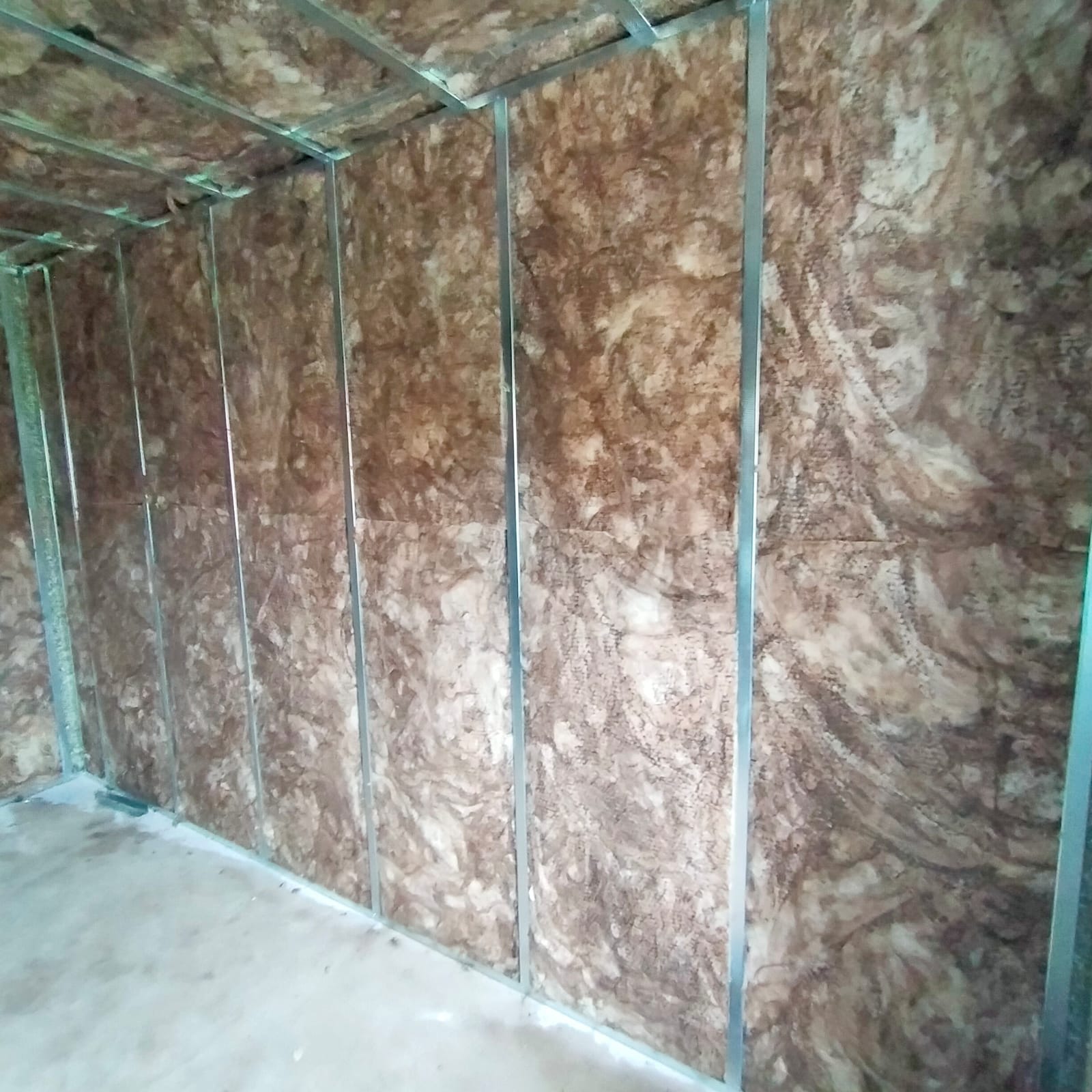 Una habitación con una pared recubierta de aislamiento y una estructura de metal.