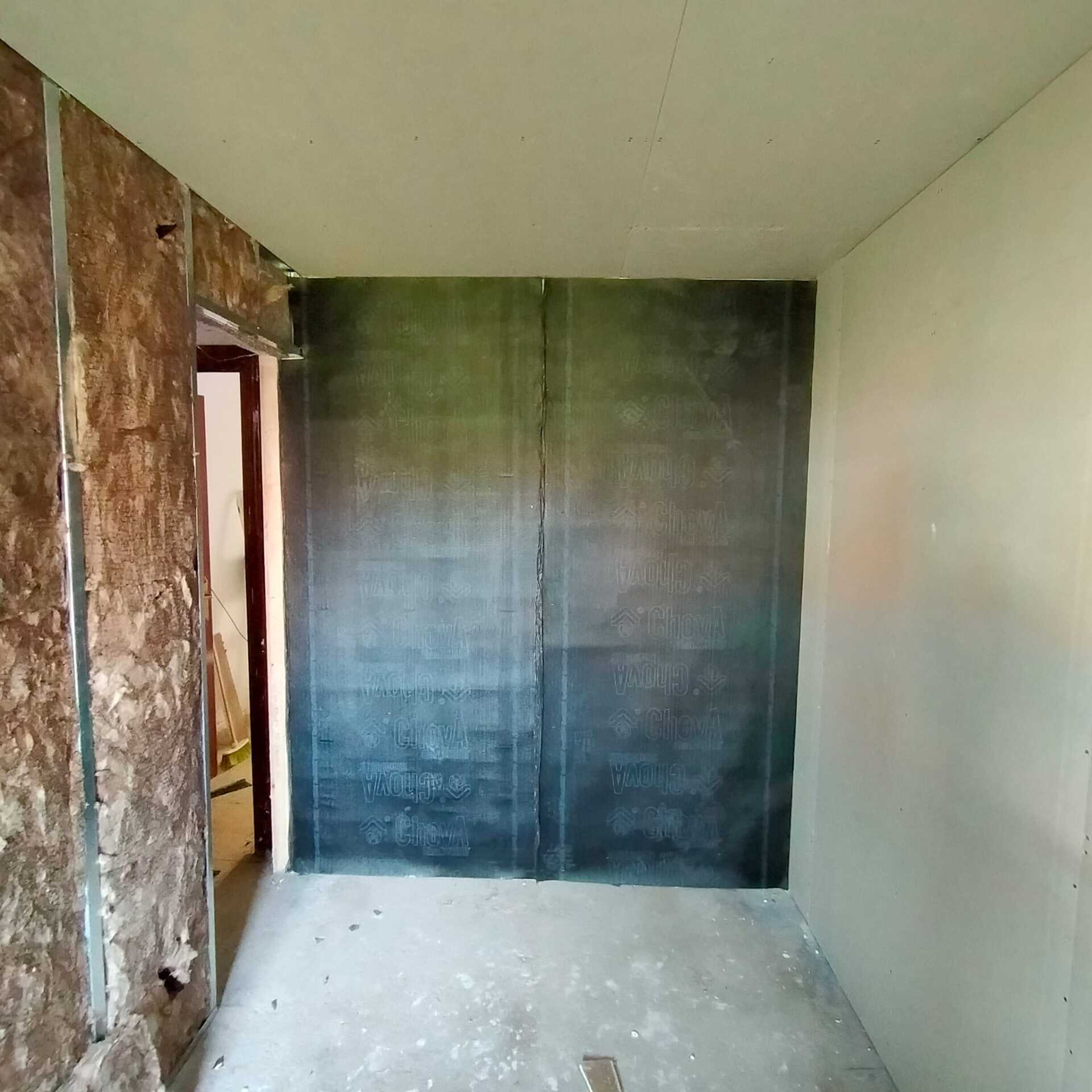 Una habitación vacía con una puerta y una pared negra