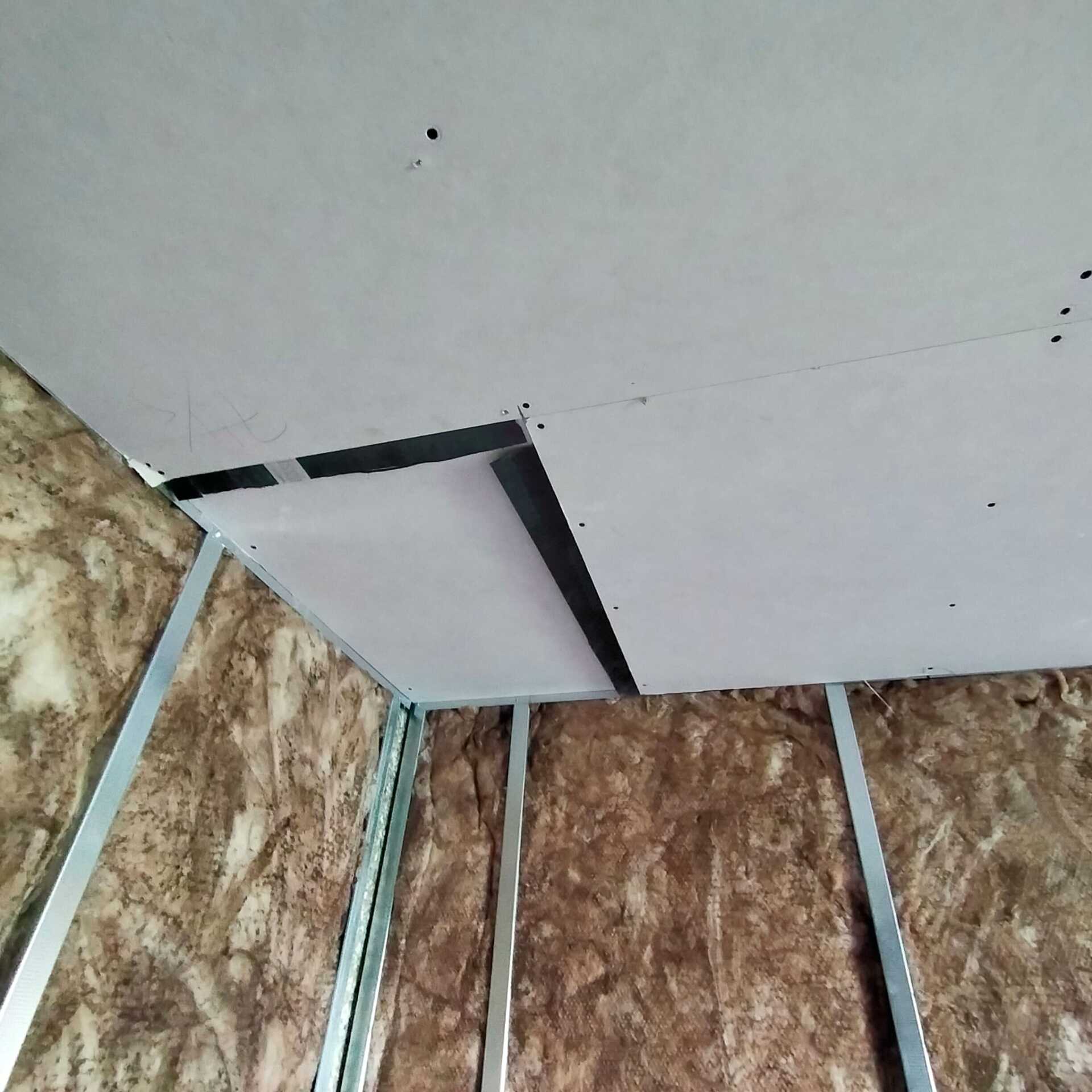 Una esquina de una habitación con un techo y una pared