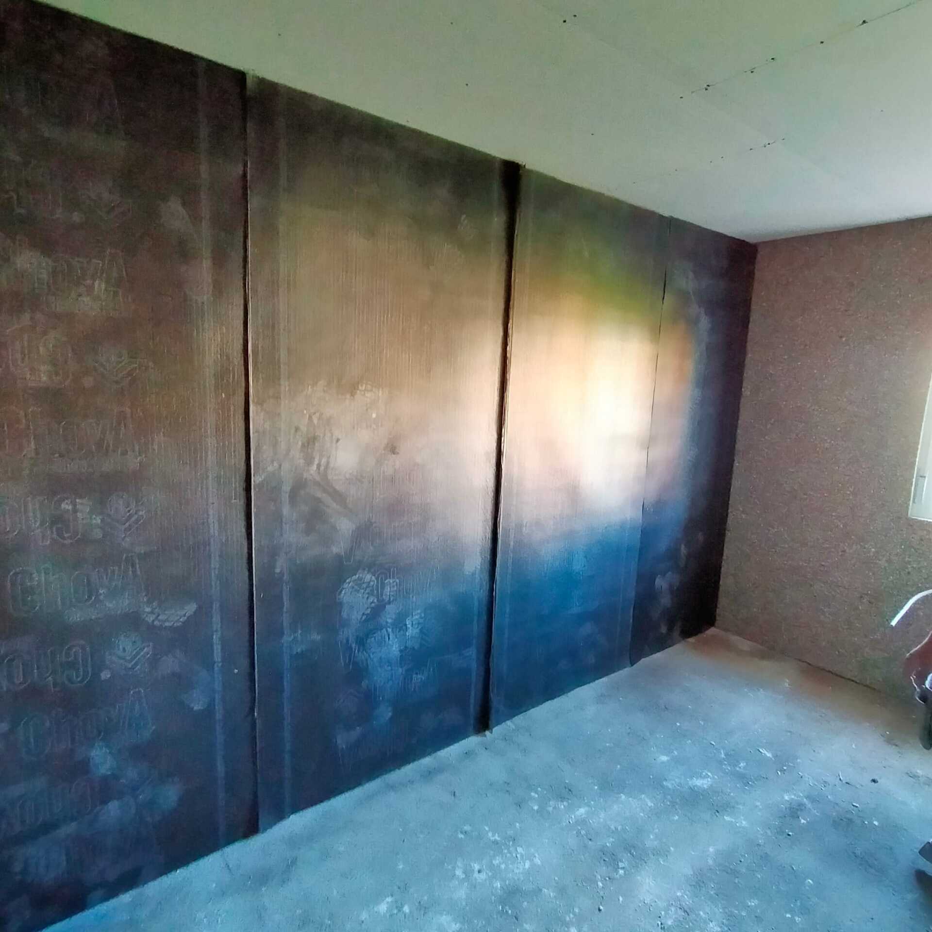 Una habitación con una pared grande y piso de concreto