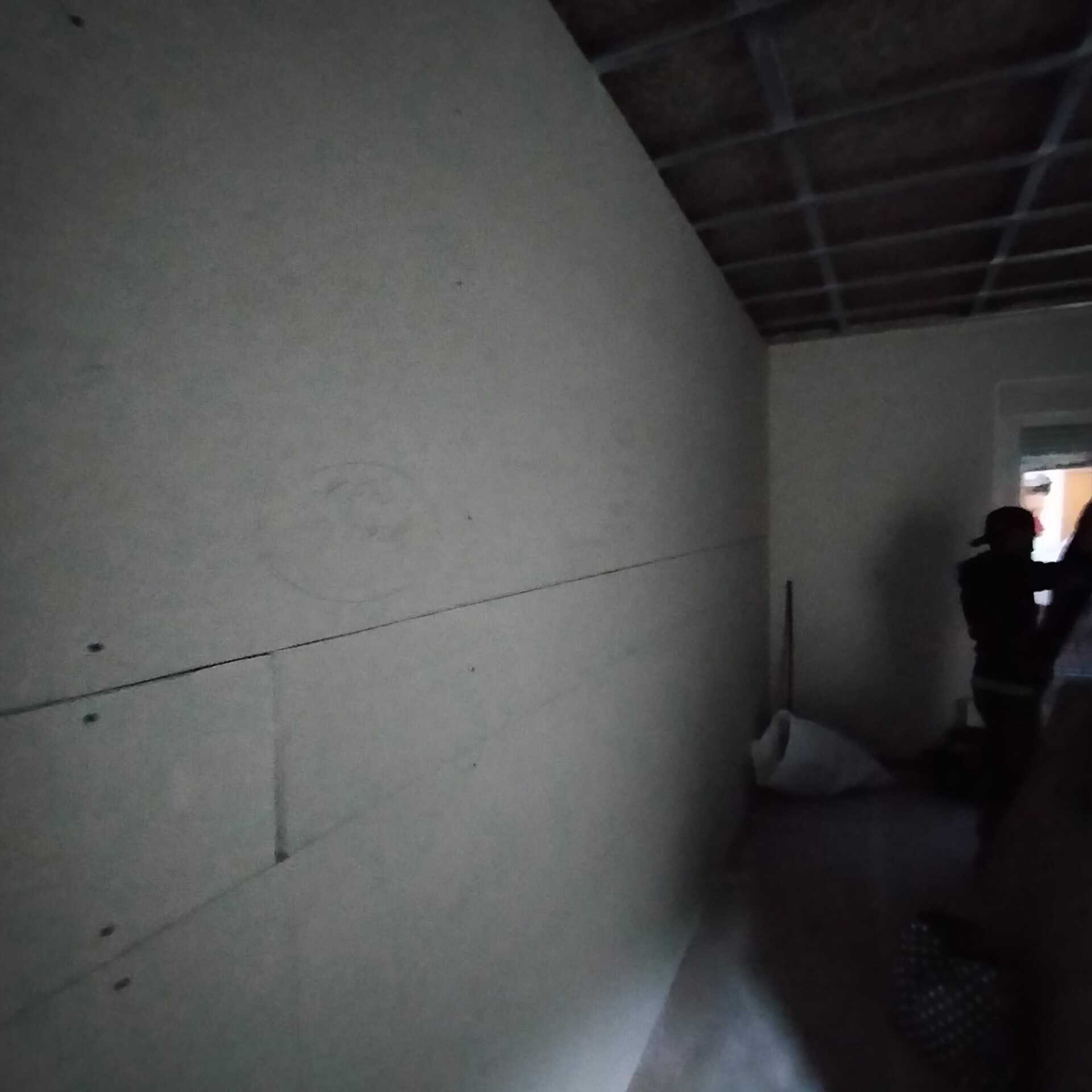 Una persona está parada en una habitación con una pared blanca