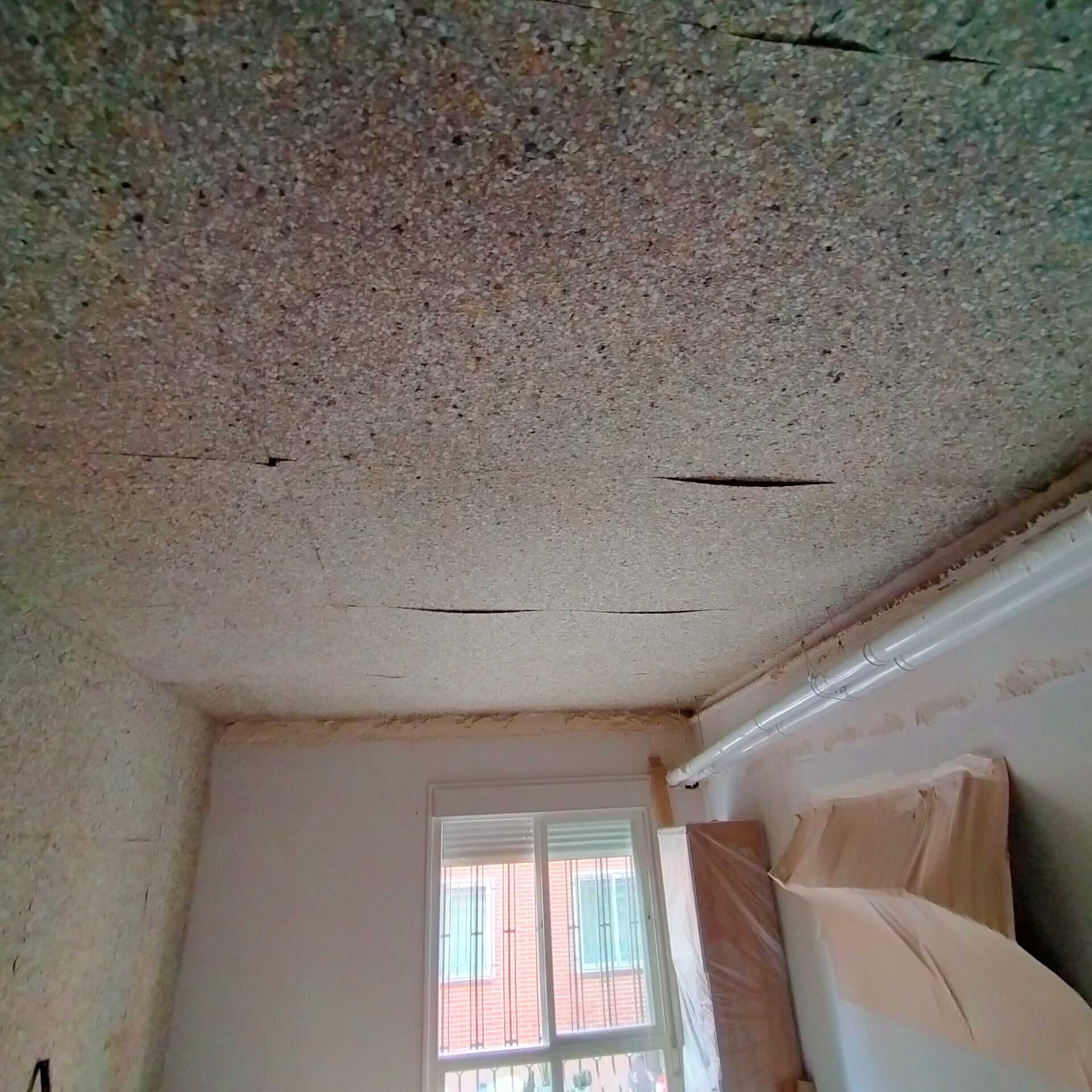 Una habitación con techo de madera y ventana.