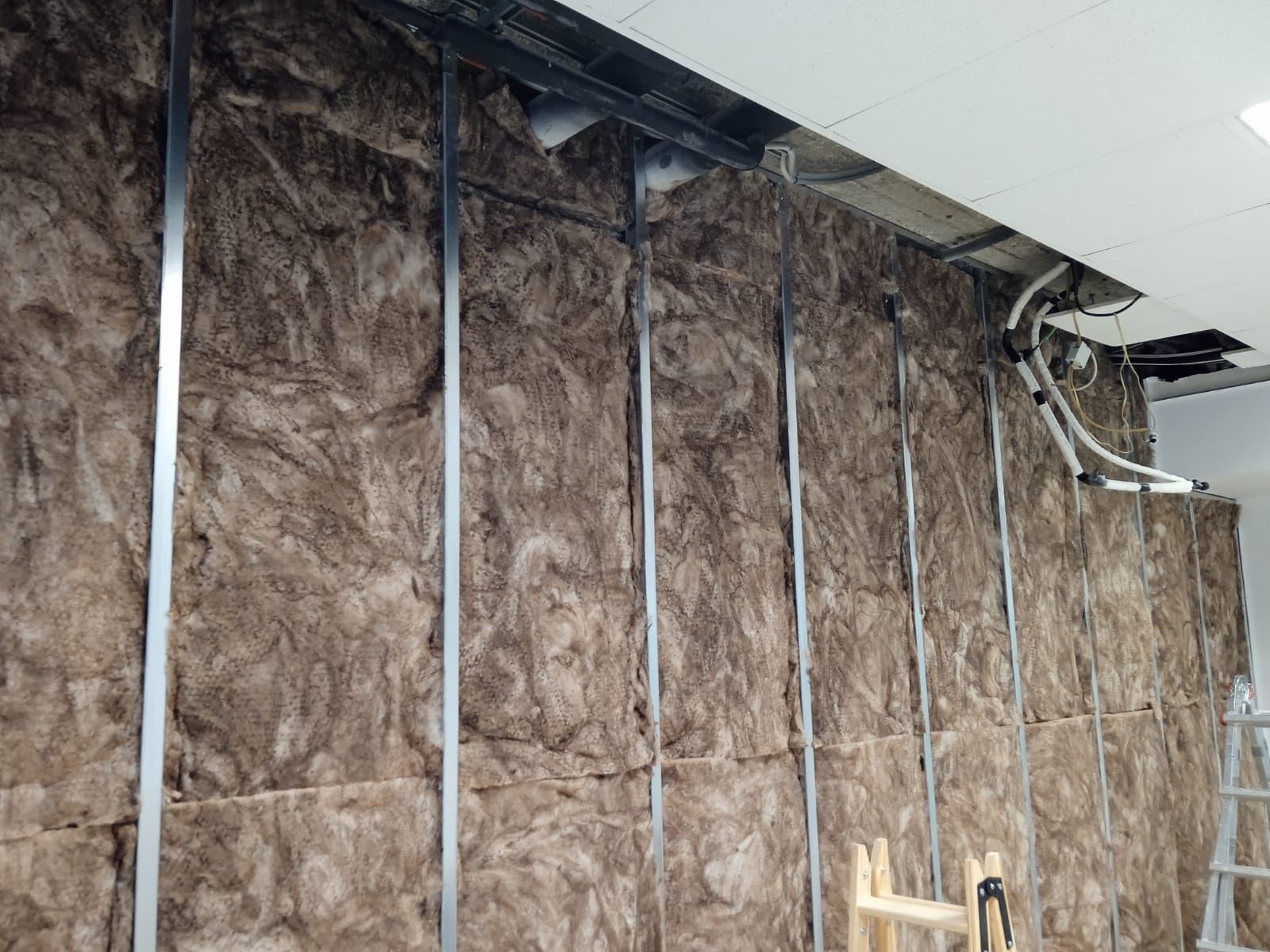 Una pared con mucho aislamiento y una escalera al fondo.