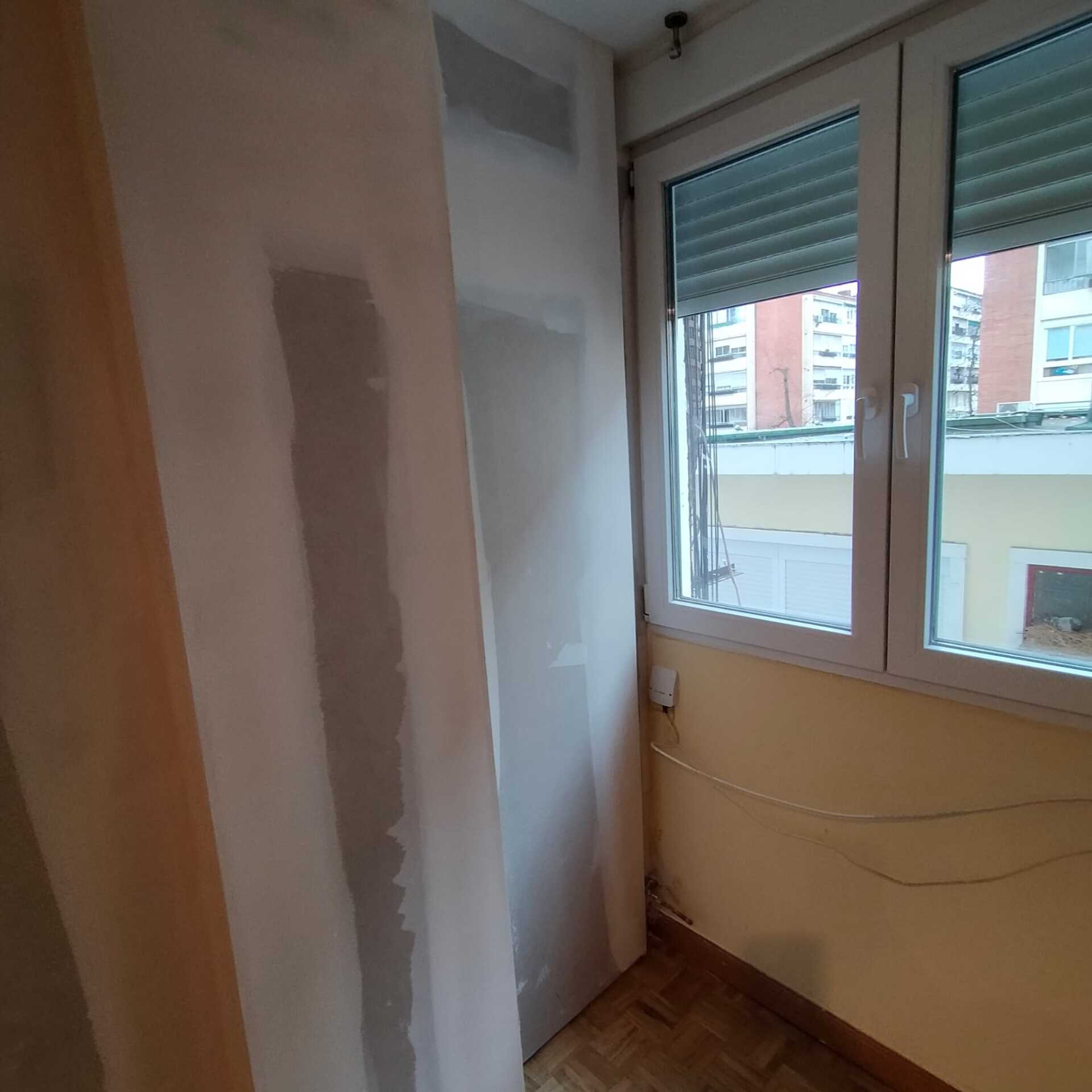 Una habitación con una ventana y una contraventana.