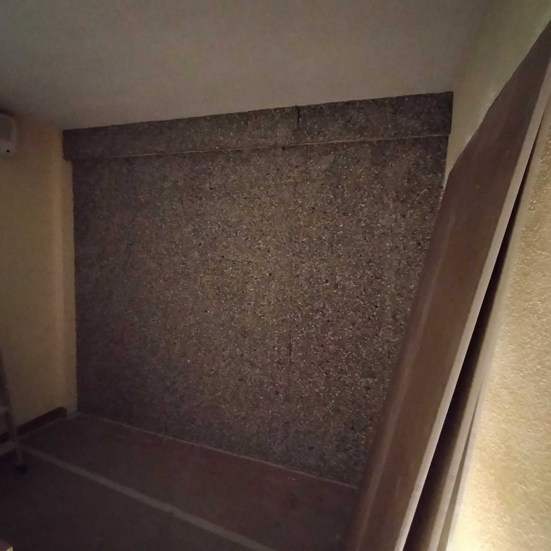 Una habitación con una pared gris y una puerta