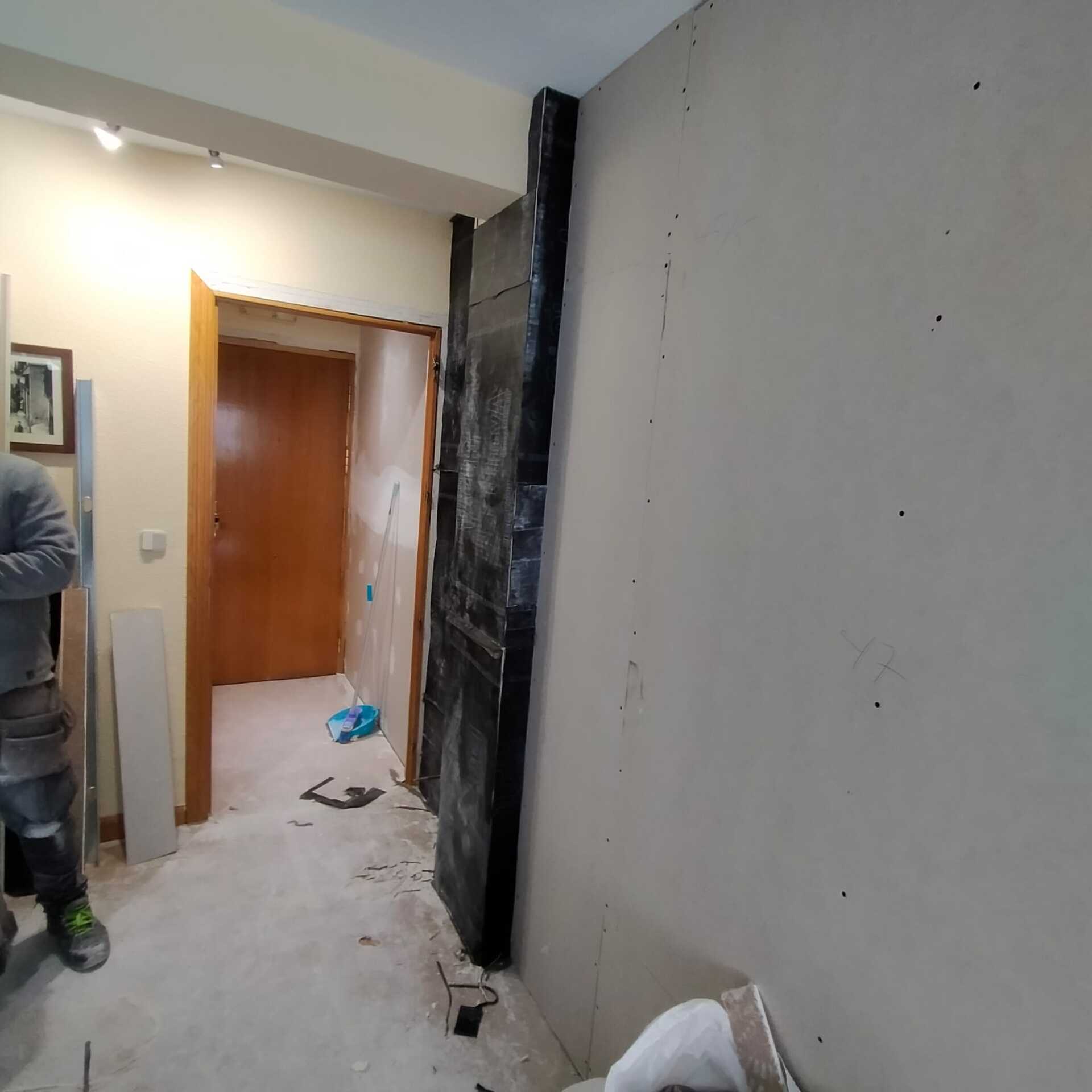 Un hombre está parado en un pasillo al lado de una puerta