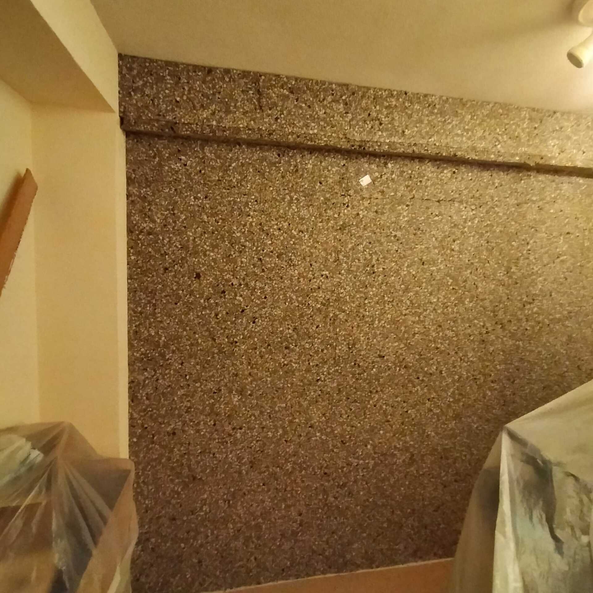 Una habitación con una pared que tiene muchas piedras pequeñas