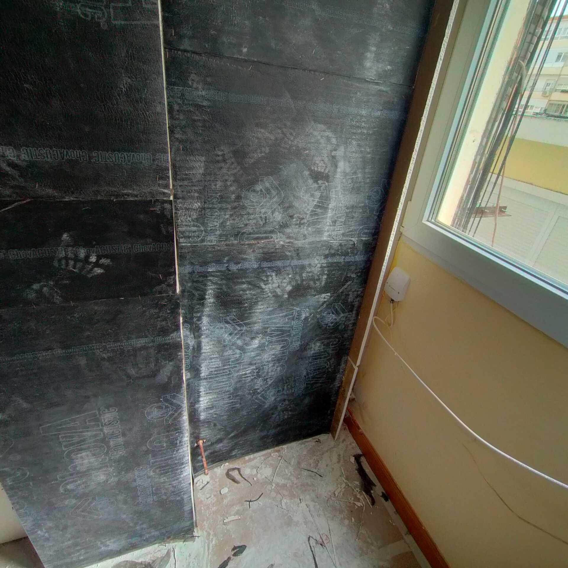 Una habitación con una pared negra y una ventana